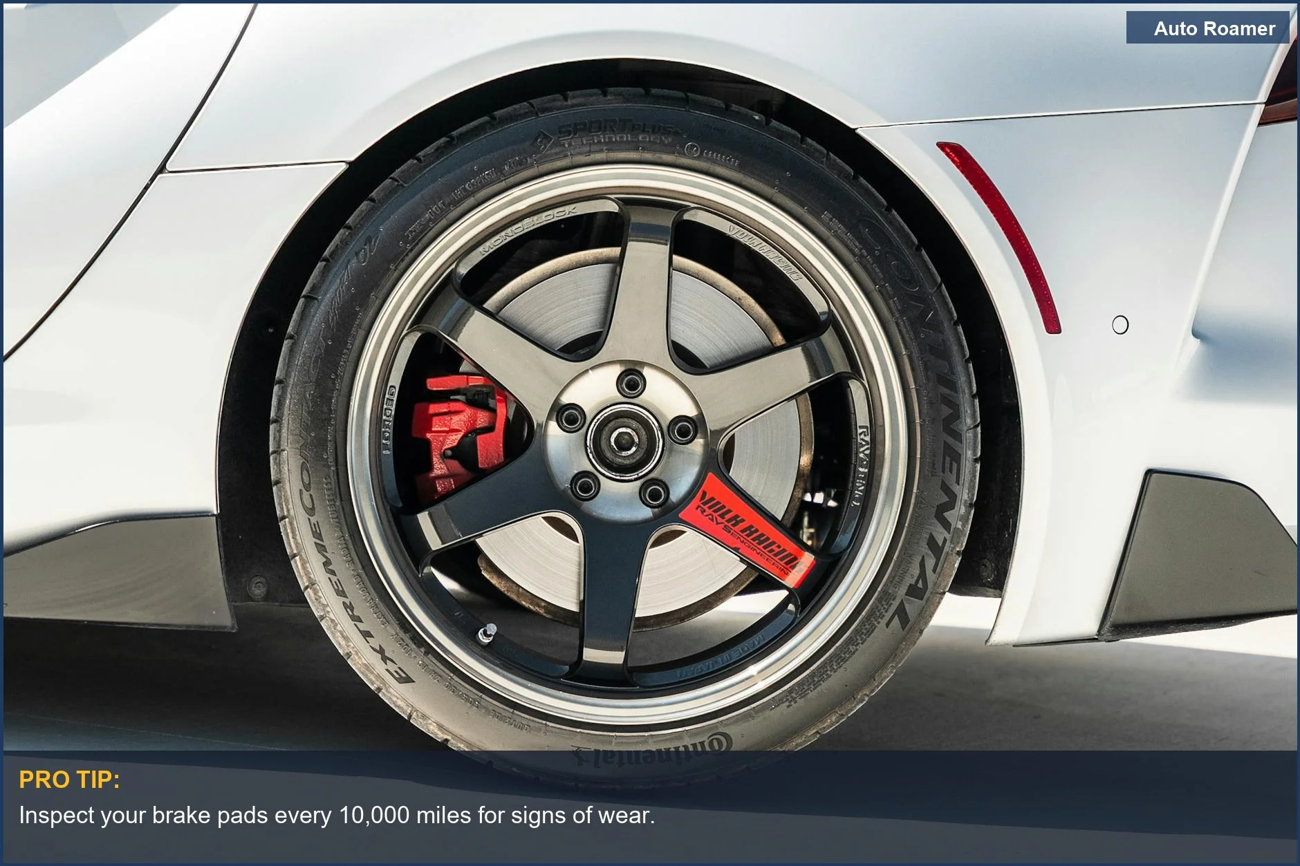 Sports car wheel with red brake caliper, a sign of potential brake pad wear.