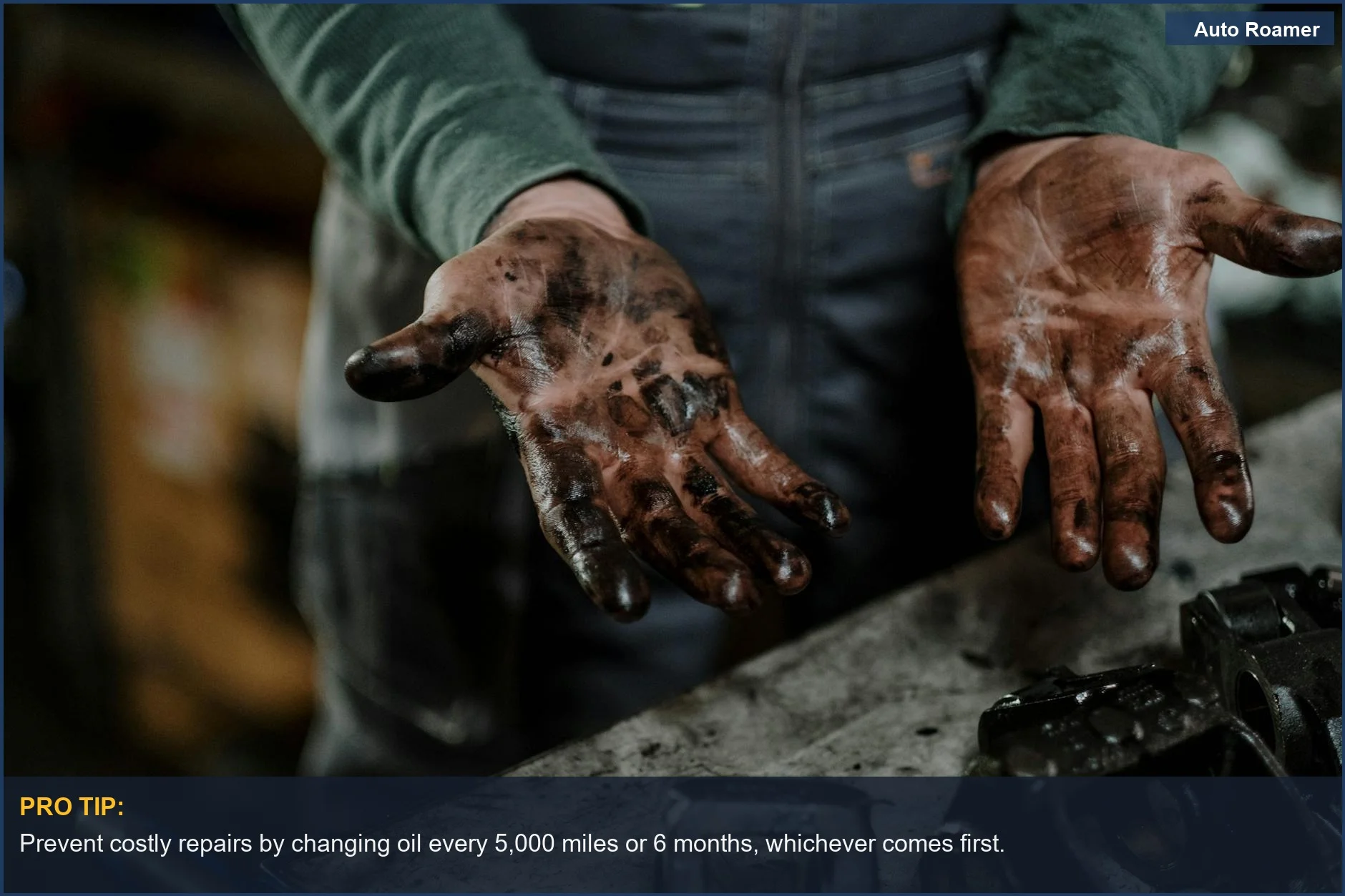 Mechanic's dirty hands in garage, illustrating car maintenance and engine wear.