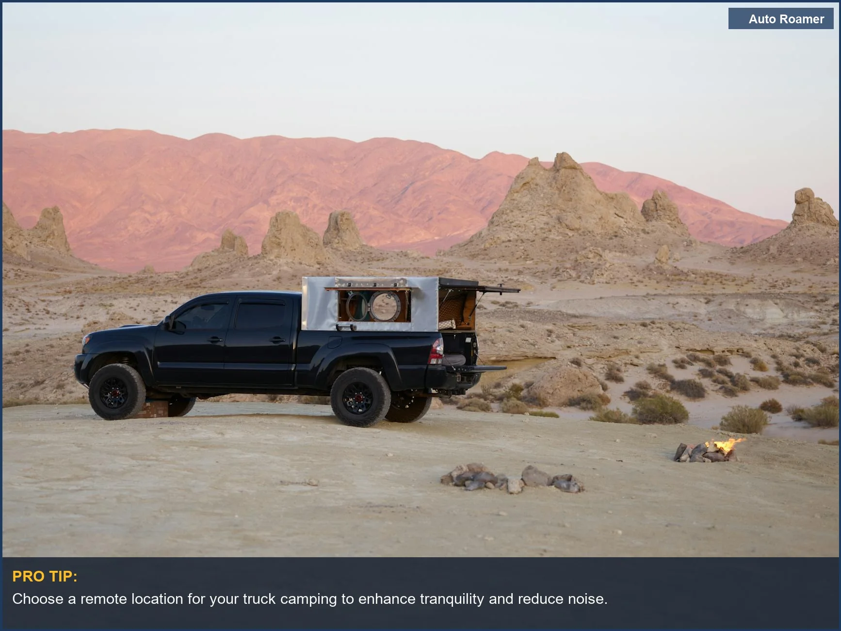 A black pickup truck in a desert at sunset showcasing a simple truck camping setup.