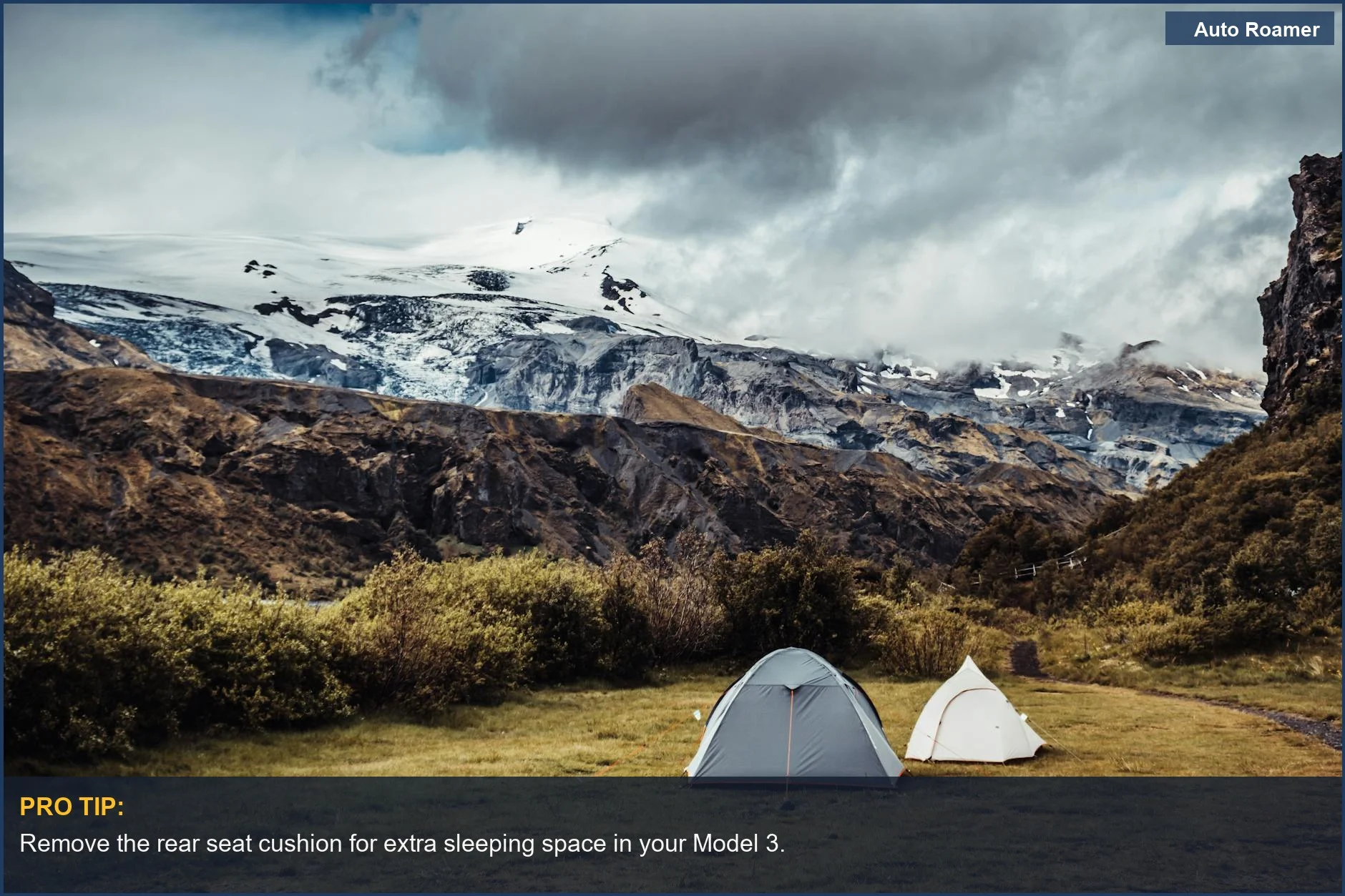 Two tents set up at a beautiful mountain campsite with a Tesla Model 3.