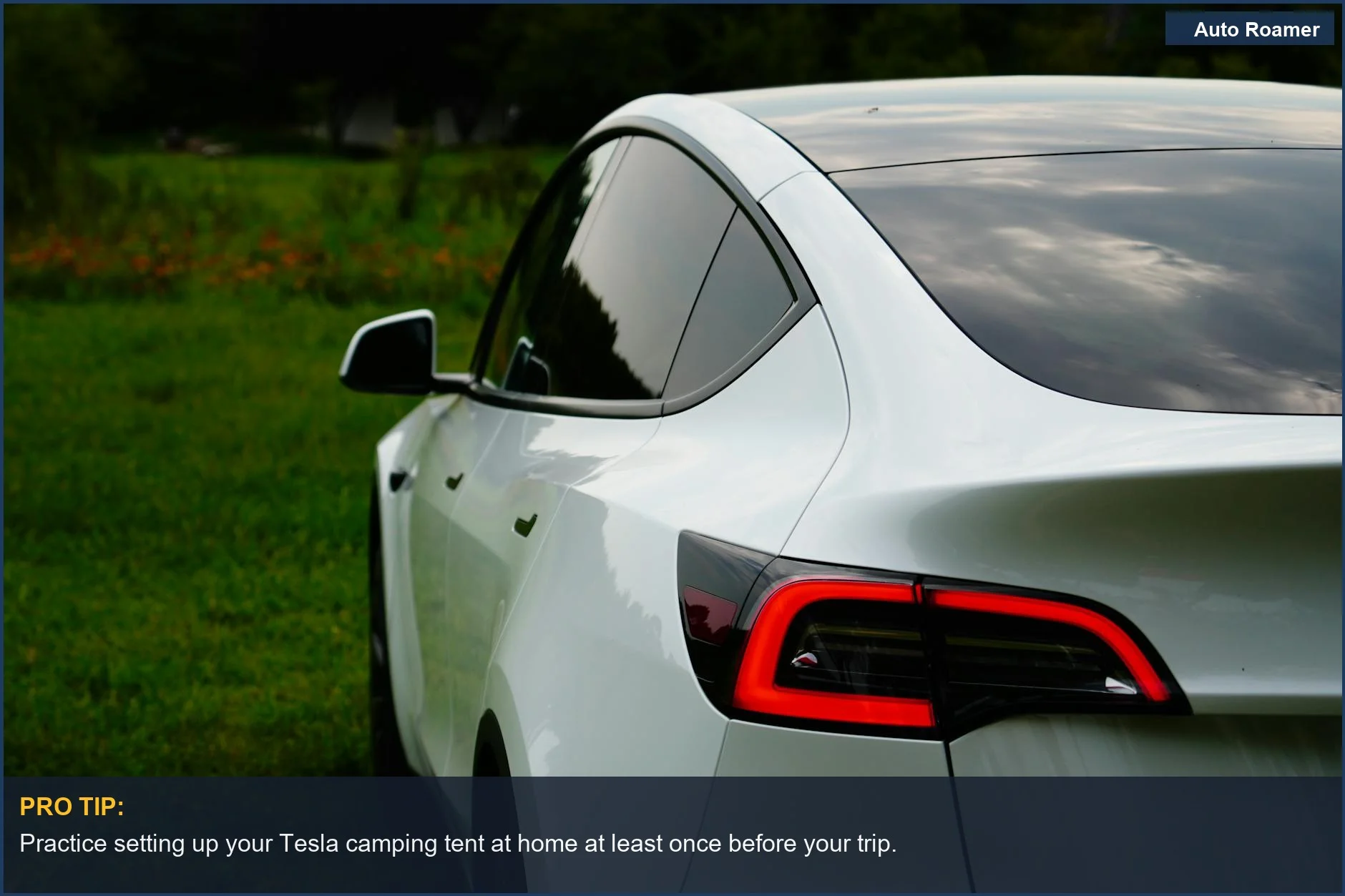White Tesla Model Y in a green landscape, perfect for extending living space with a Tesla camping tent attachment.