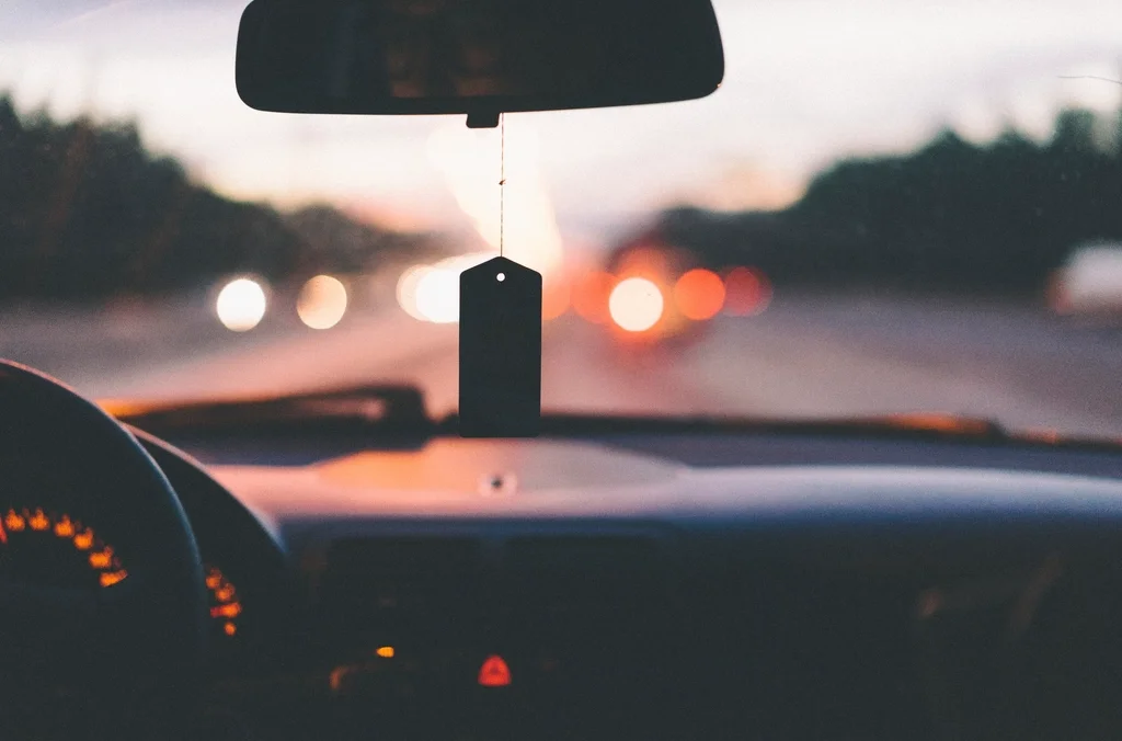 A disposable air freshener hanging from a car's rearview mirror, the single-use product this article weighs the environmental cost of.