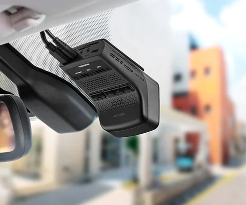 a Thinkware U3000 Pro mounted on a windshield next to the rear-view mirror with 4K UHD on its body