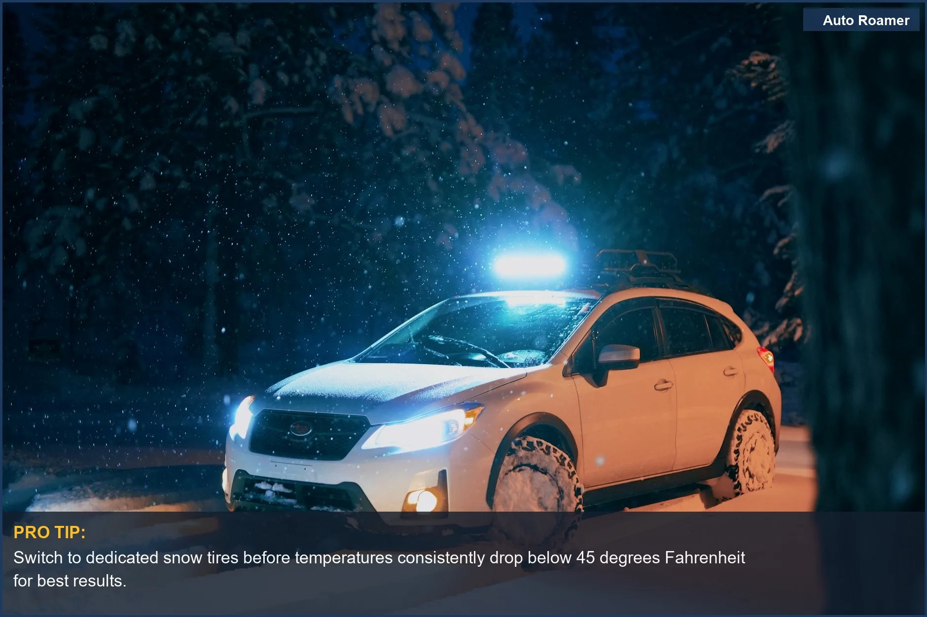 White car with headlights on driving on a snow-covered road at night, ensuring winter driving safety.