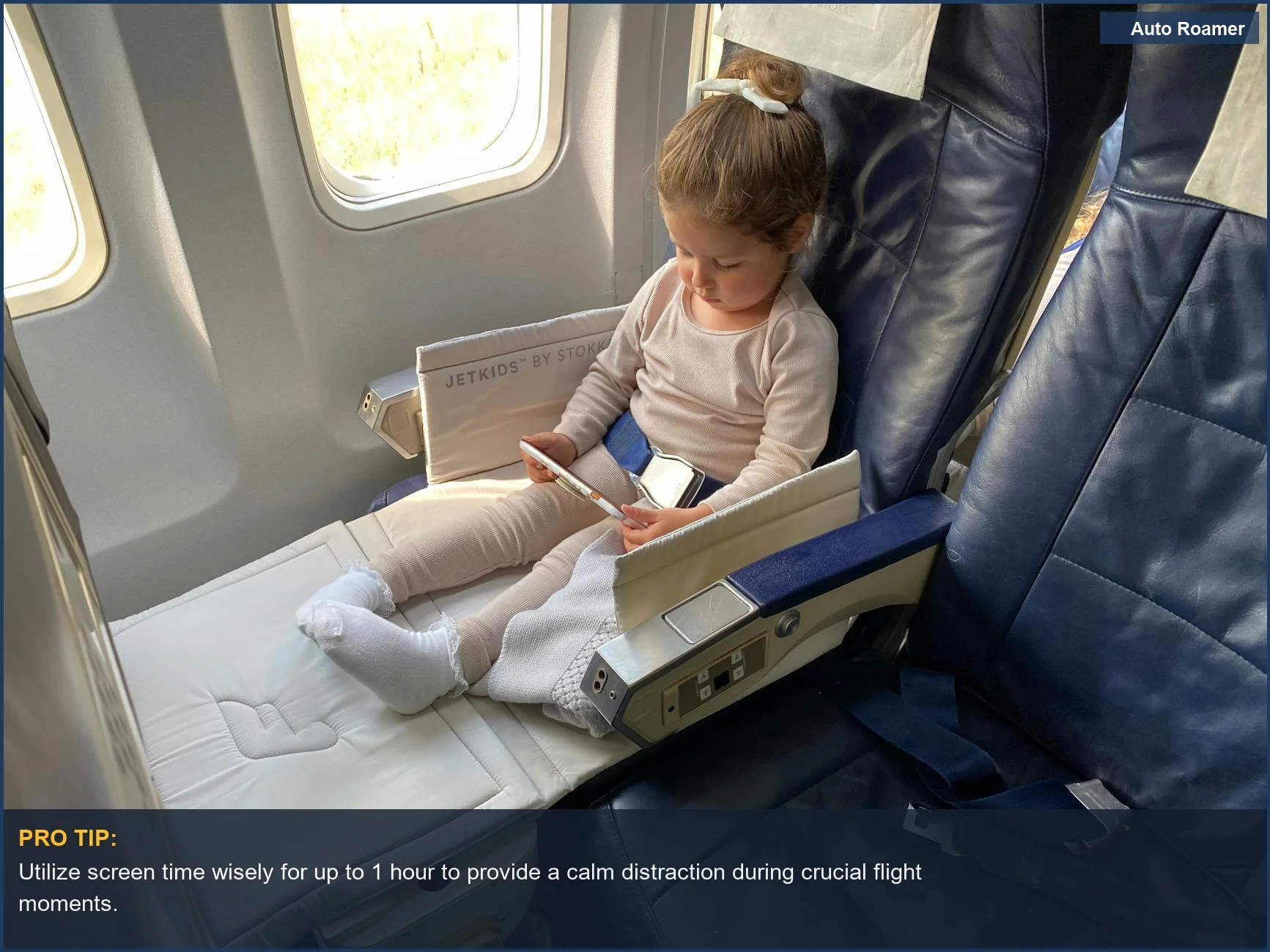 Young girl uses a tablet in an airplane seat, a key toddler travel essential for entertainment.