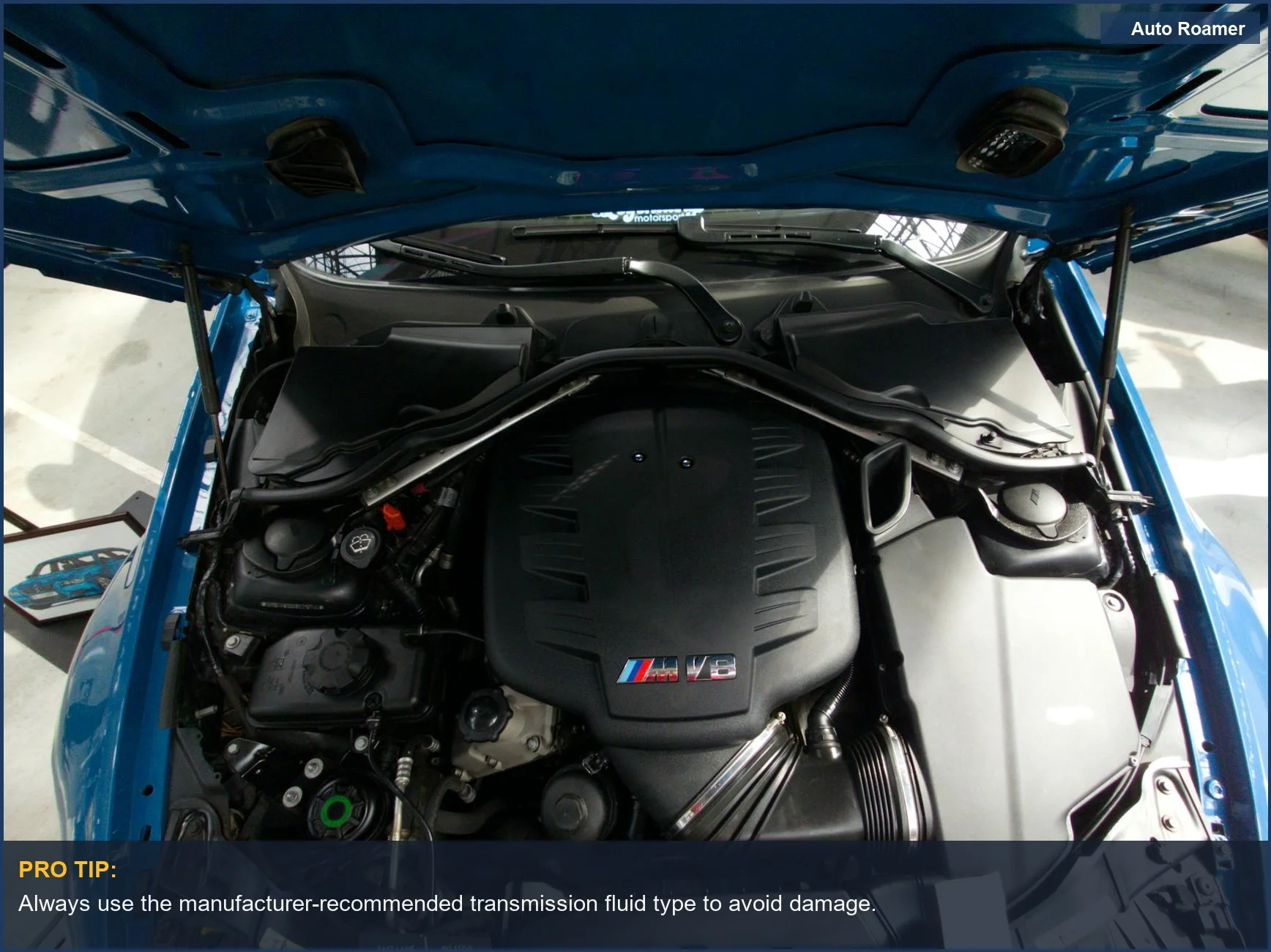 Close-up view of a car's V8 engine bay, highlighting transmission fluid dipstick.
