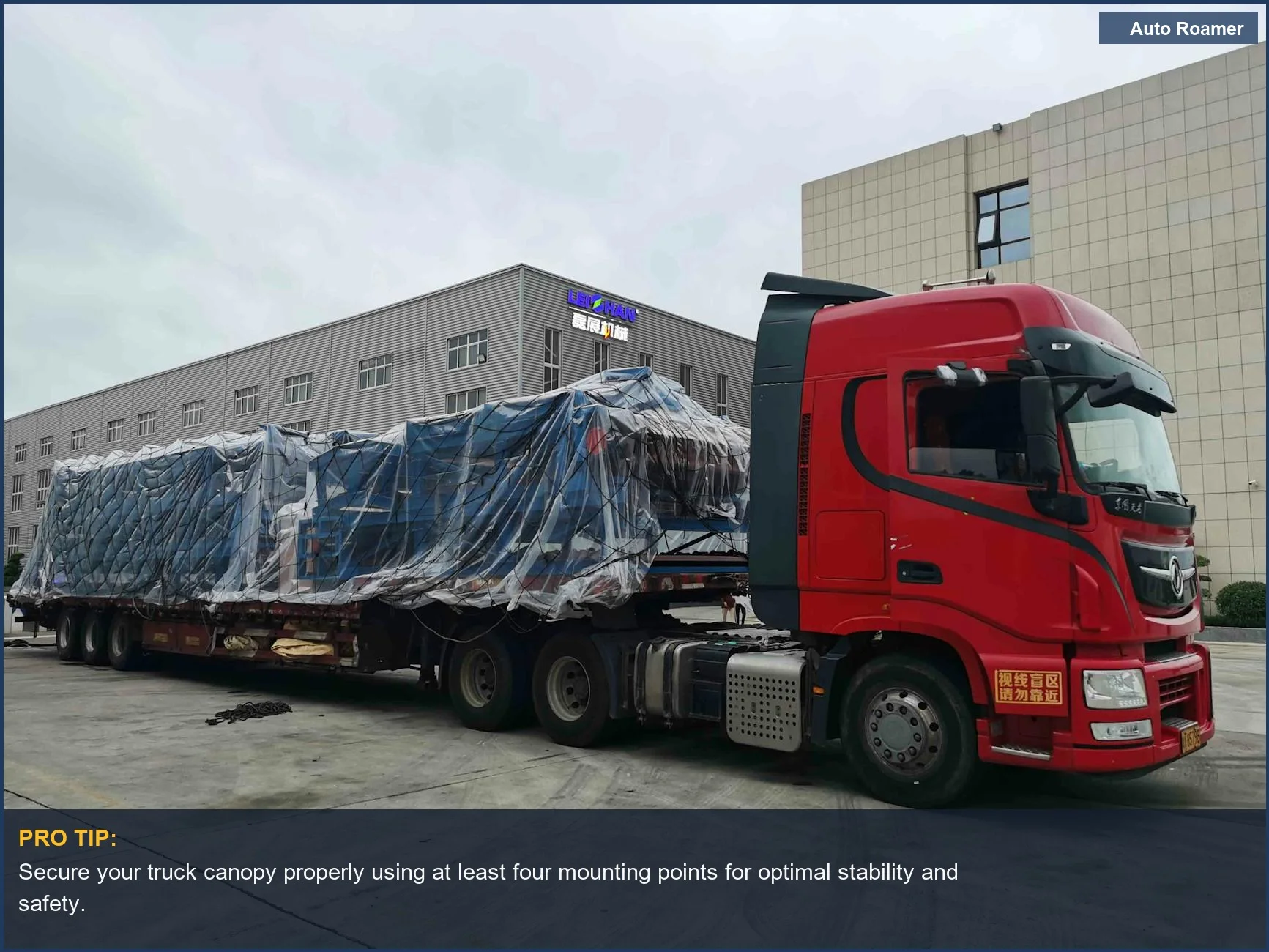 Red truck with large covered cargo in an industrial area, emphasizing installation considerations for truck bed canopies.