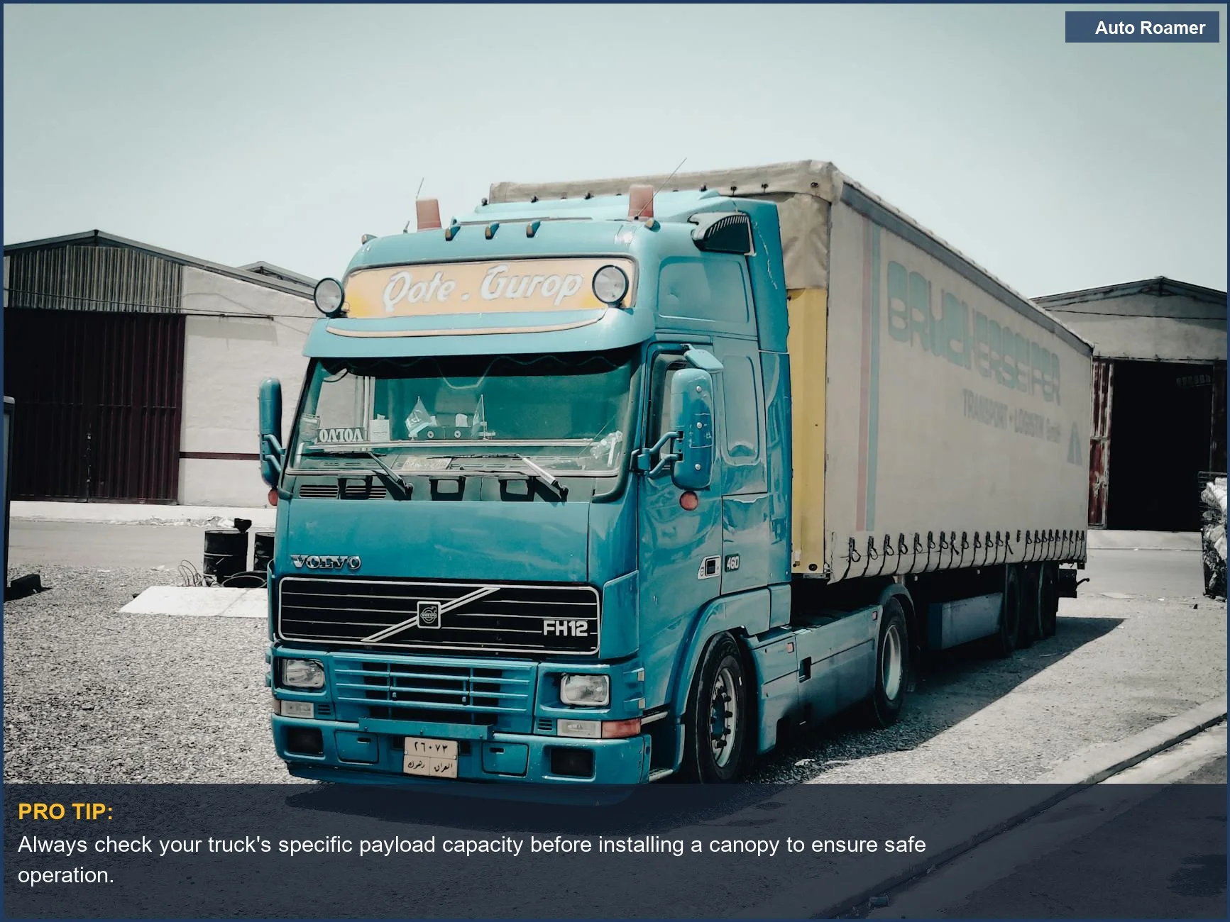 Blue Volvo truck parked outside a warehouse, illustrating payload capacity considerations for truck canopy weight limit.
