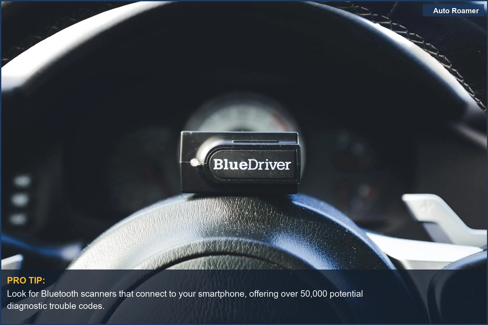 Lector de códigos OBD2 BlueDriver sobre el volante de un coche, listo para diagnósticos automotrices.