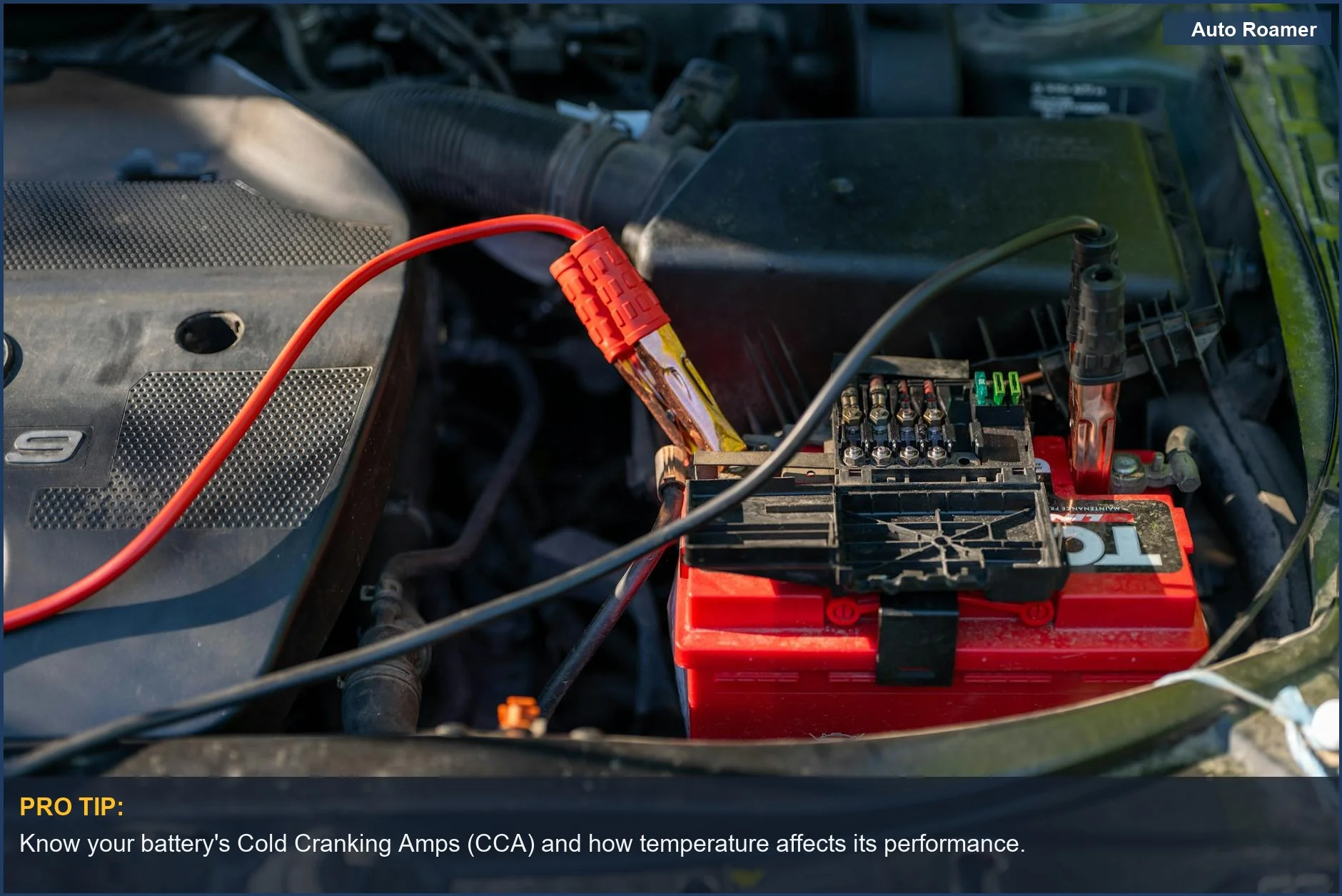 Close-up of a car battery with jumper cables connected, vital for understanding car battery drain while camping.
