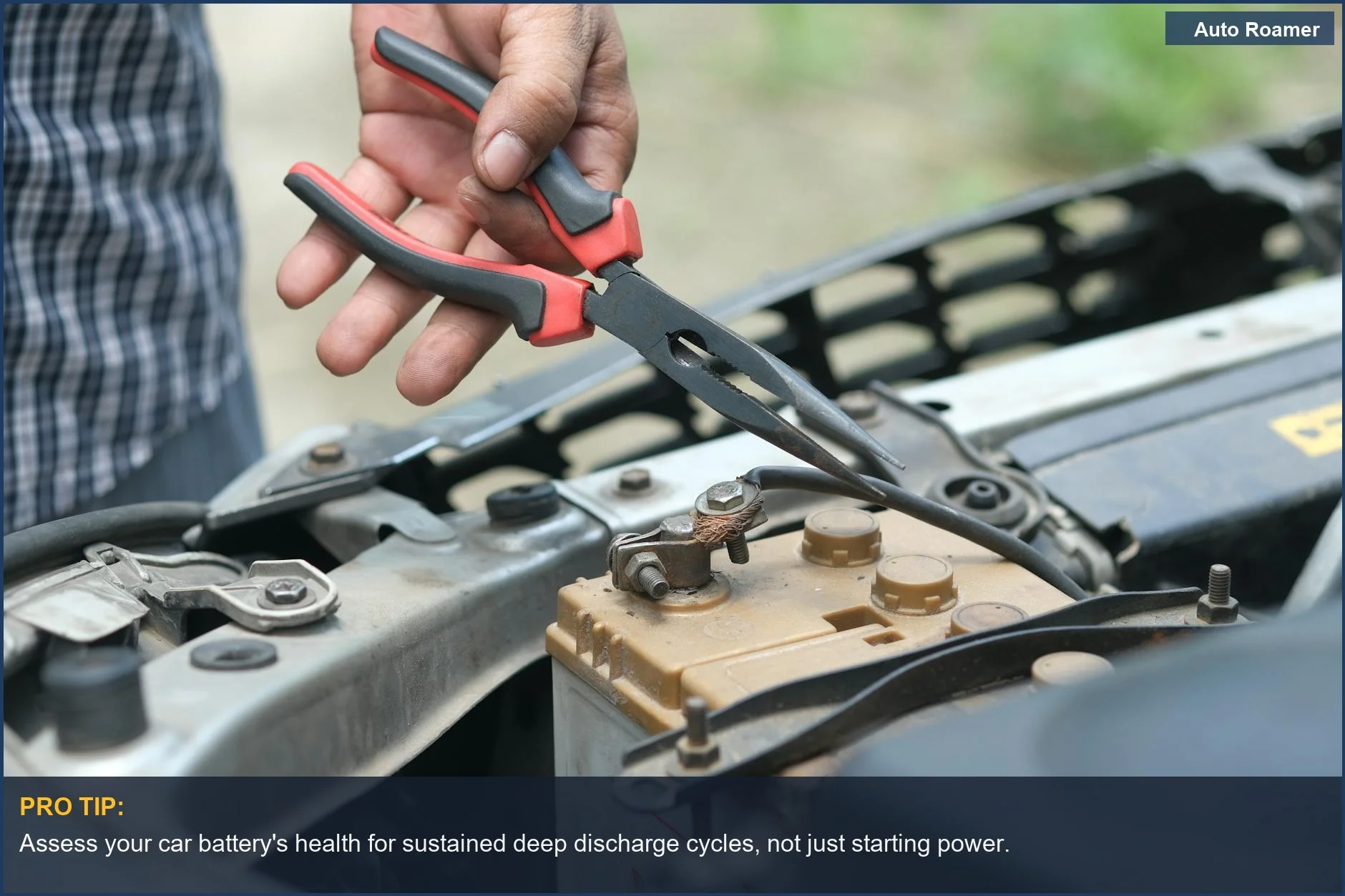 Person inspecting a car battery with tools, addressing car battery drain during camping trips.