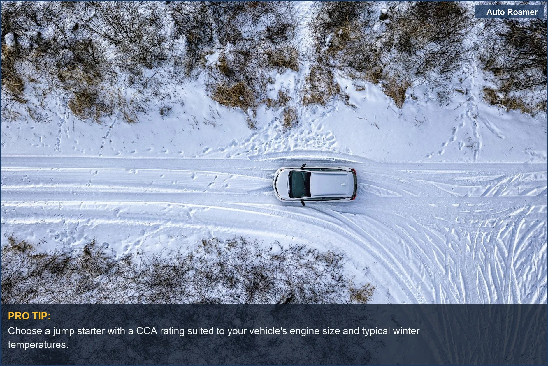 Drone view of a car navigating a snowy road, emphasizing jump starter performance in challenging winter environments.