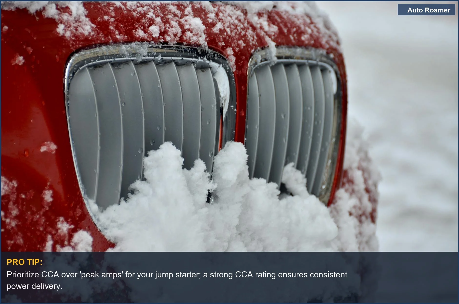 Close-up of a red car's grille frosted with snow, showing the impact of cold on vehicle components.