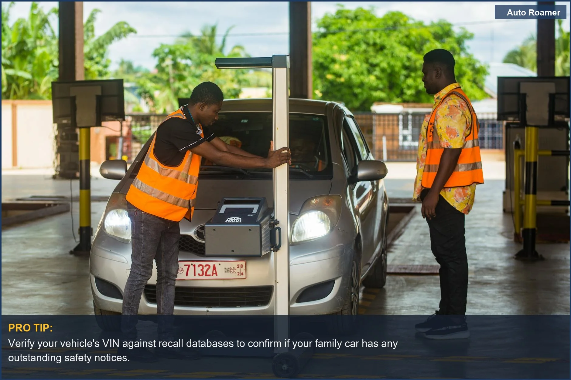 Two mechanics inspect a car in a garage, emphasizing thorough checks for family car recall notices.