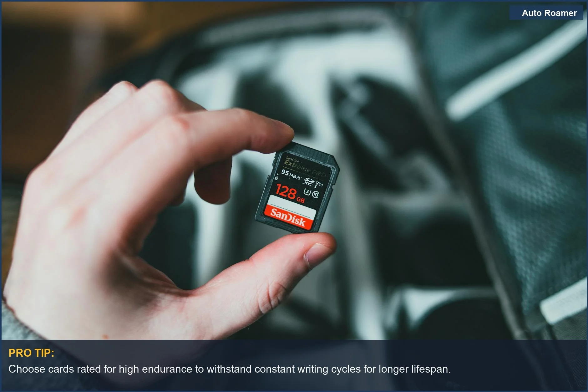 Man holding a 128GB dash cam memory card above a bag of equipment.