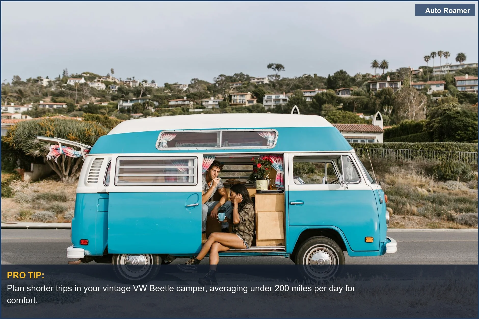 Couple on a scenic coastal road trip in a vintage VW Beetle camper, enjoying nature.