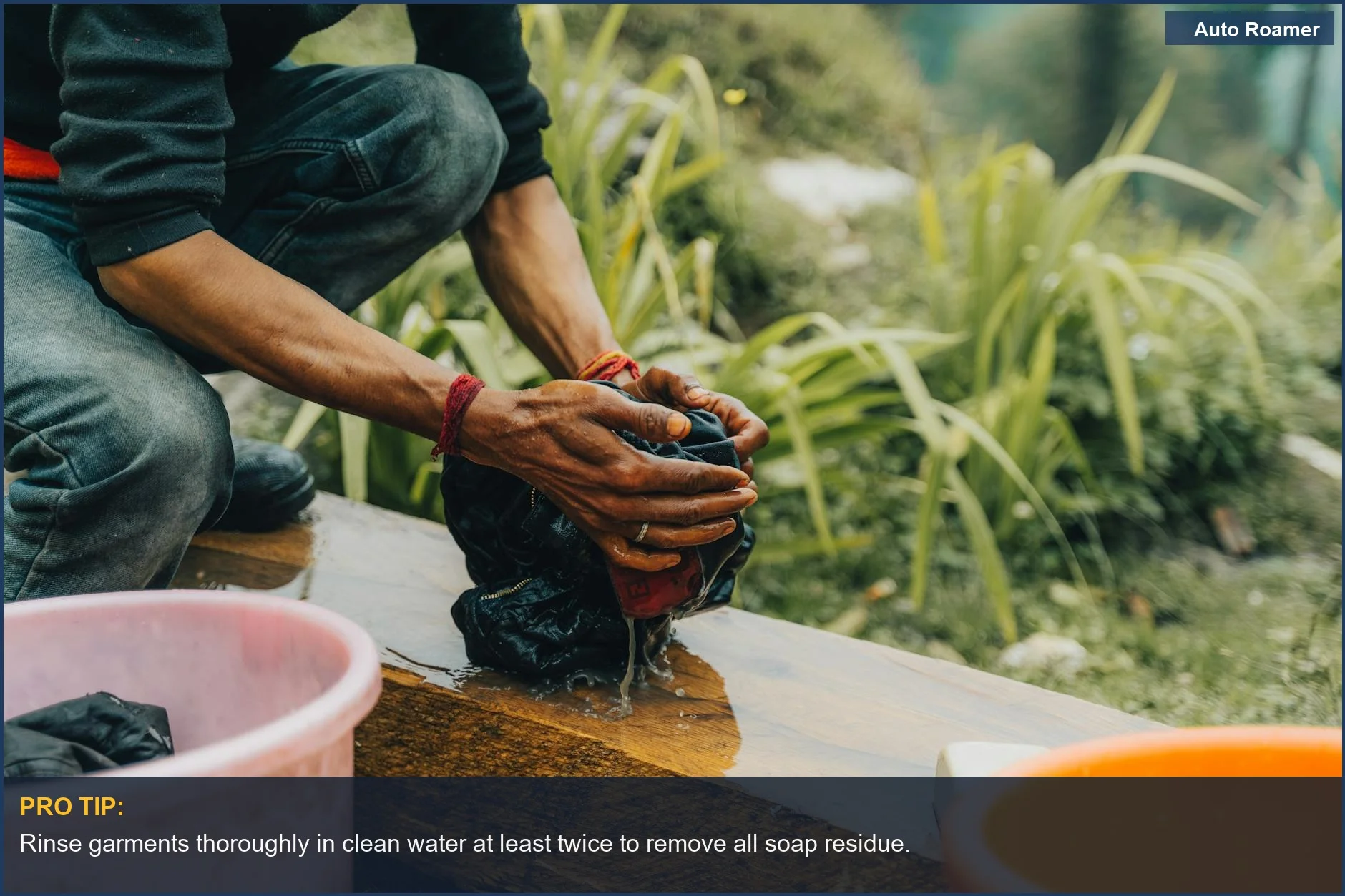 Man washing clothes by hand in a natural outdoor environment, a practical approach to car camping laundry.