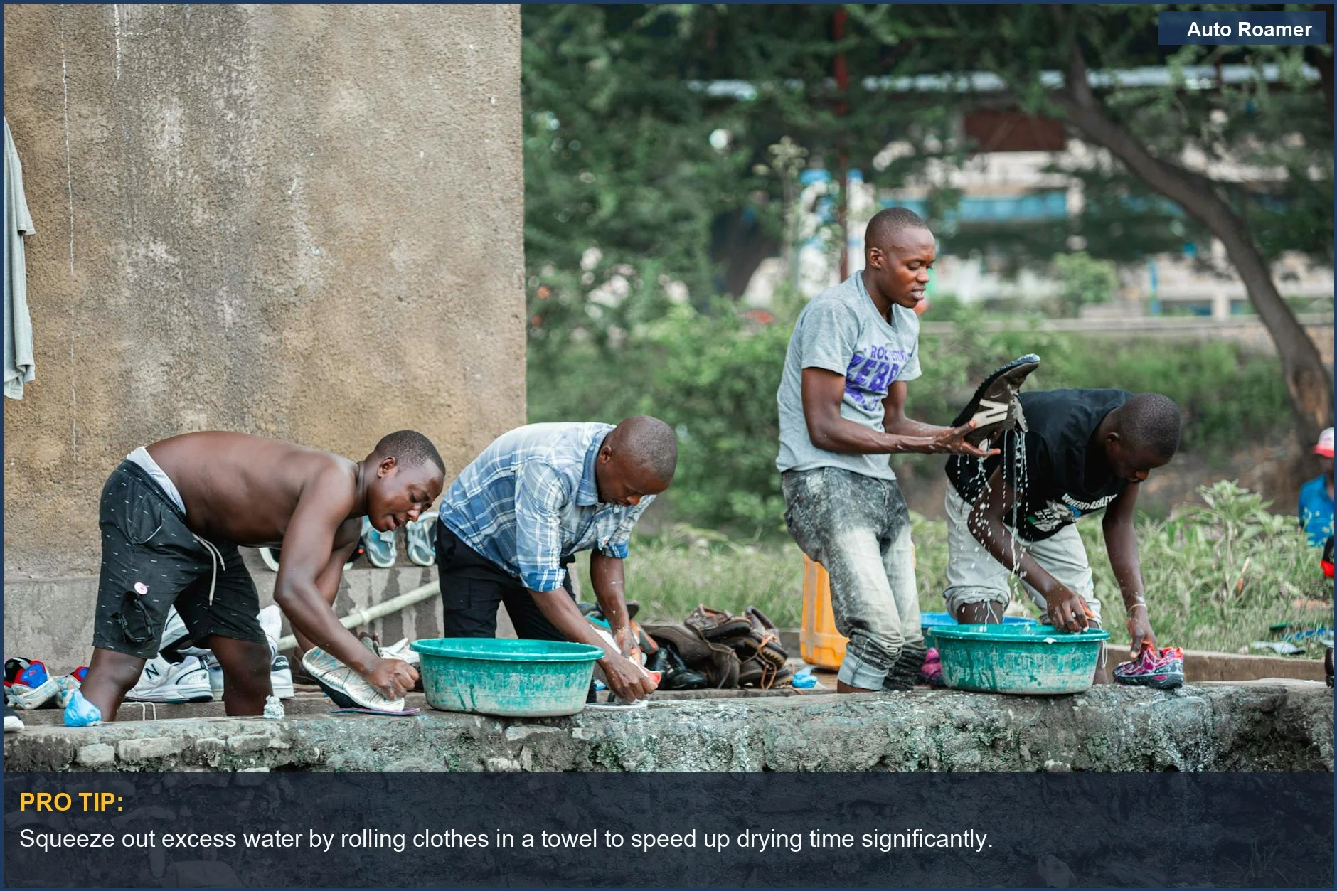Group of men doing outdoor clothes washing near a concrete wall, showcasing alternative laundry methods camping.