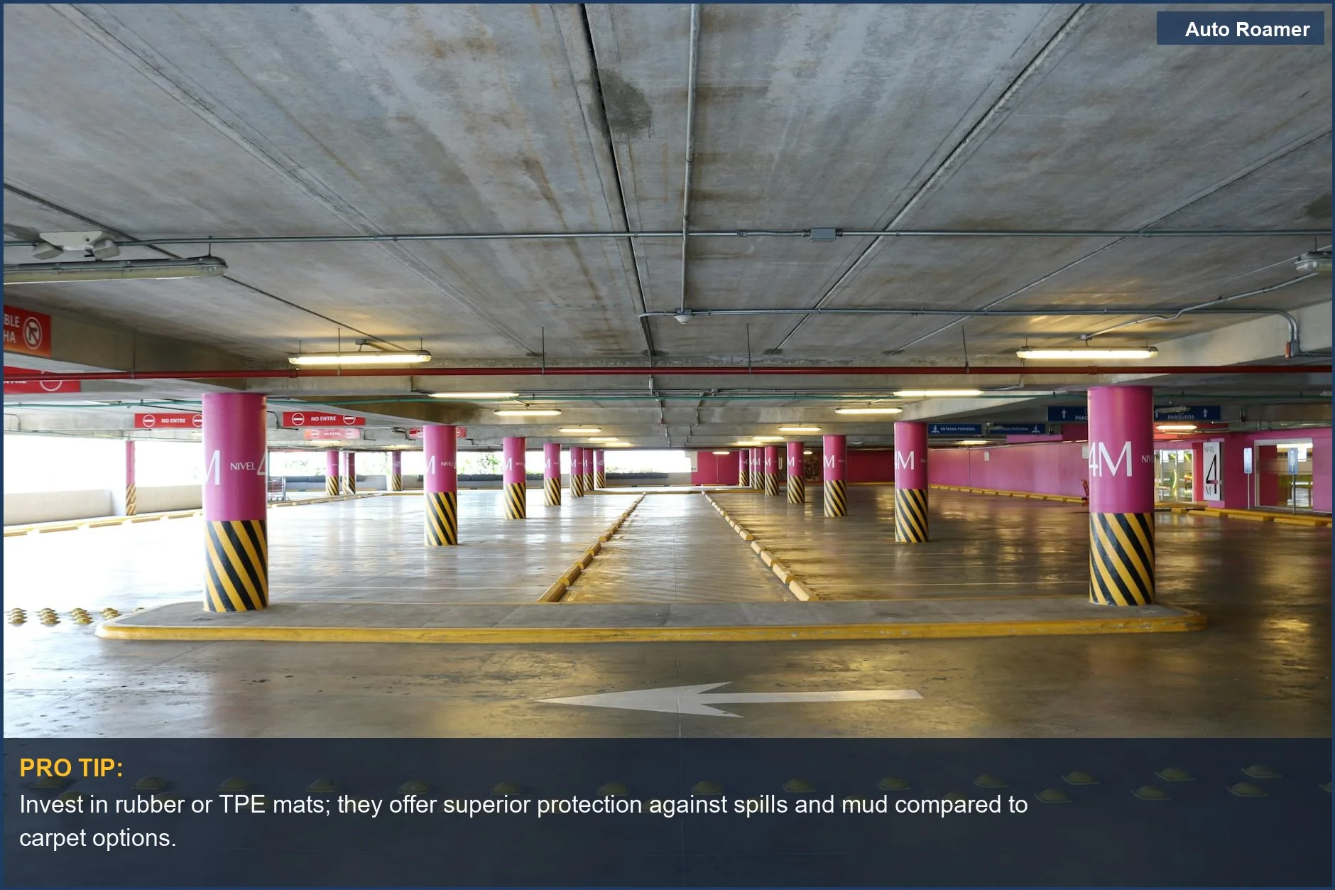 Exploring the durable all weather floor mat materials, like rubber, in an indoor parking garage with pink pillars.