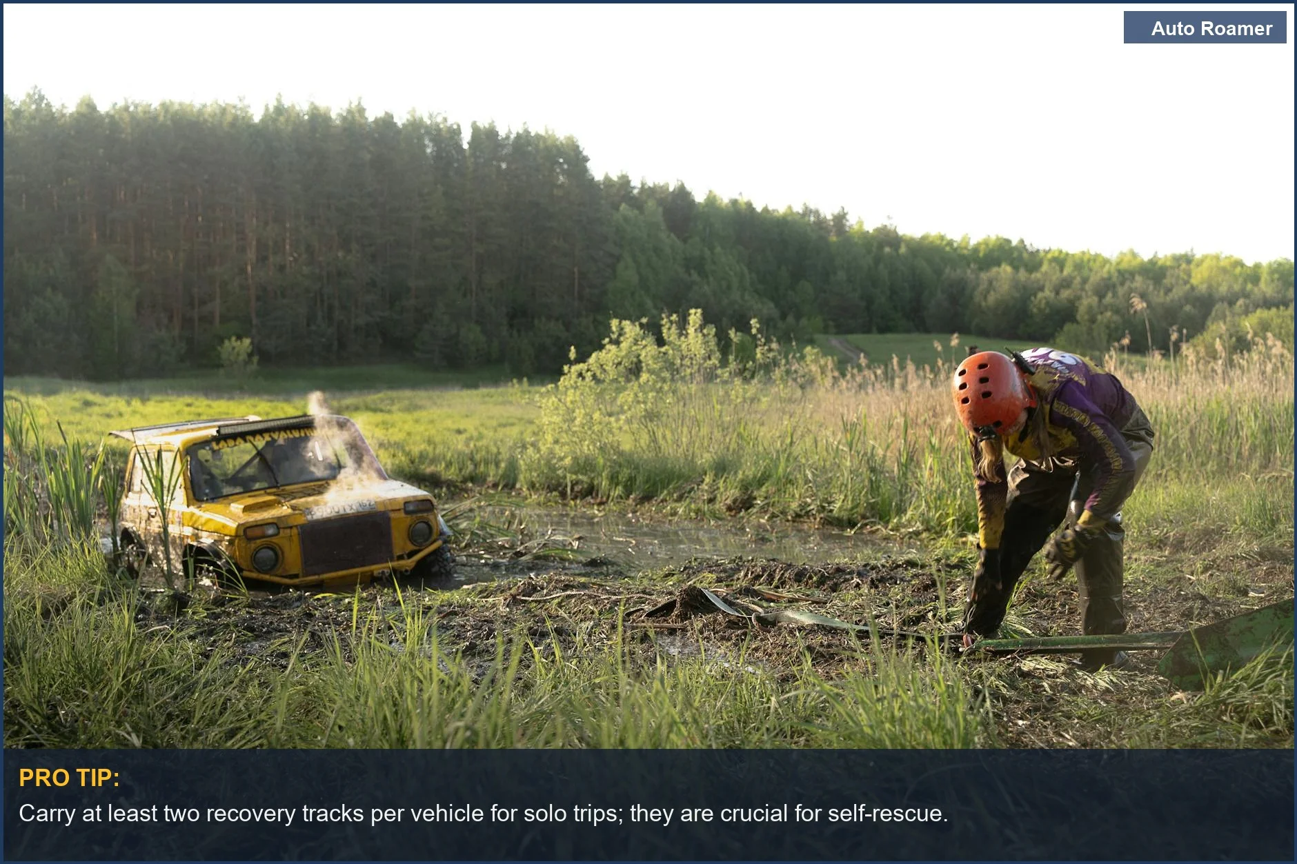 Person checking yellow off-road vehicle bogged down in mud, highlighting solo off-roading recovery needs.