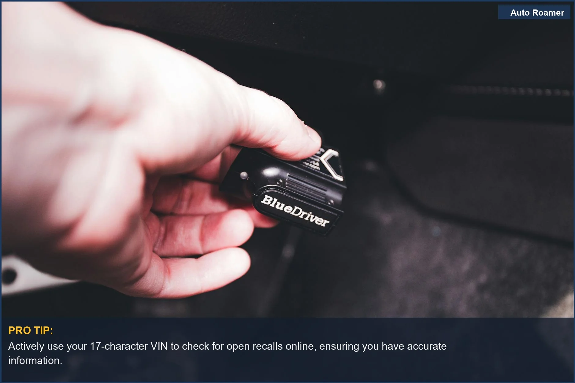 Close-up of a hand connecting a diagnostic device to a car, emphasizing VIN checks for safety recalls.