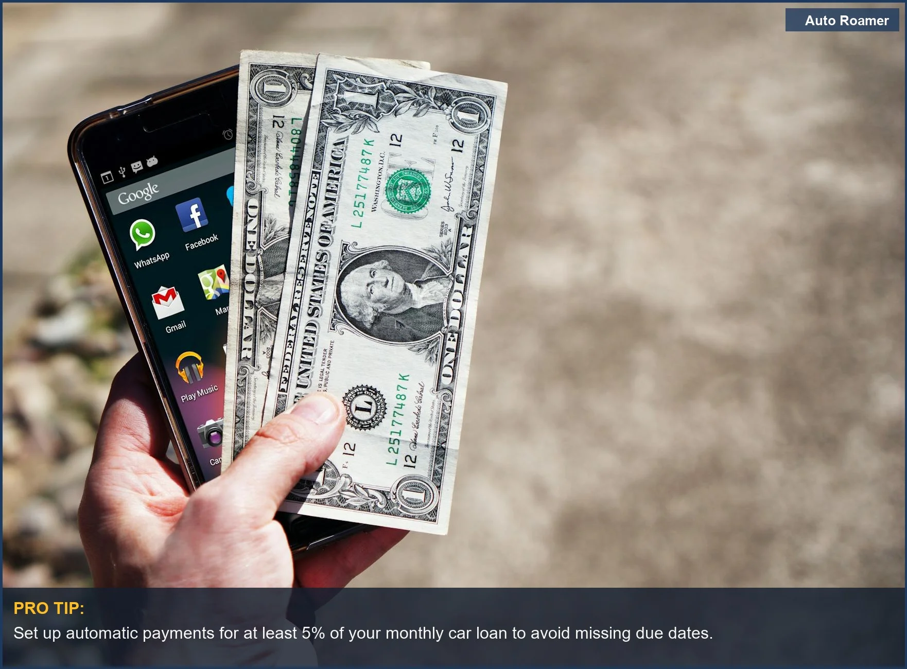 Hand holding US dollar bills and smartphone outdoors, illustrating how to manage finances and avoid car loan payment issues.