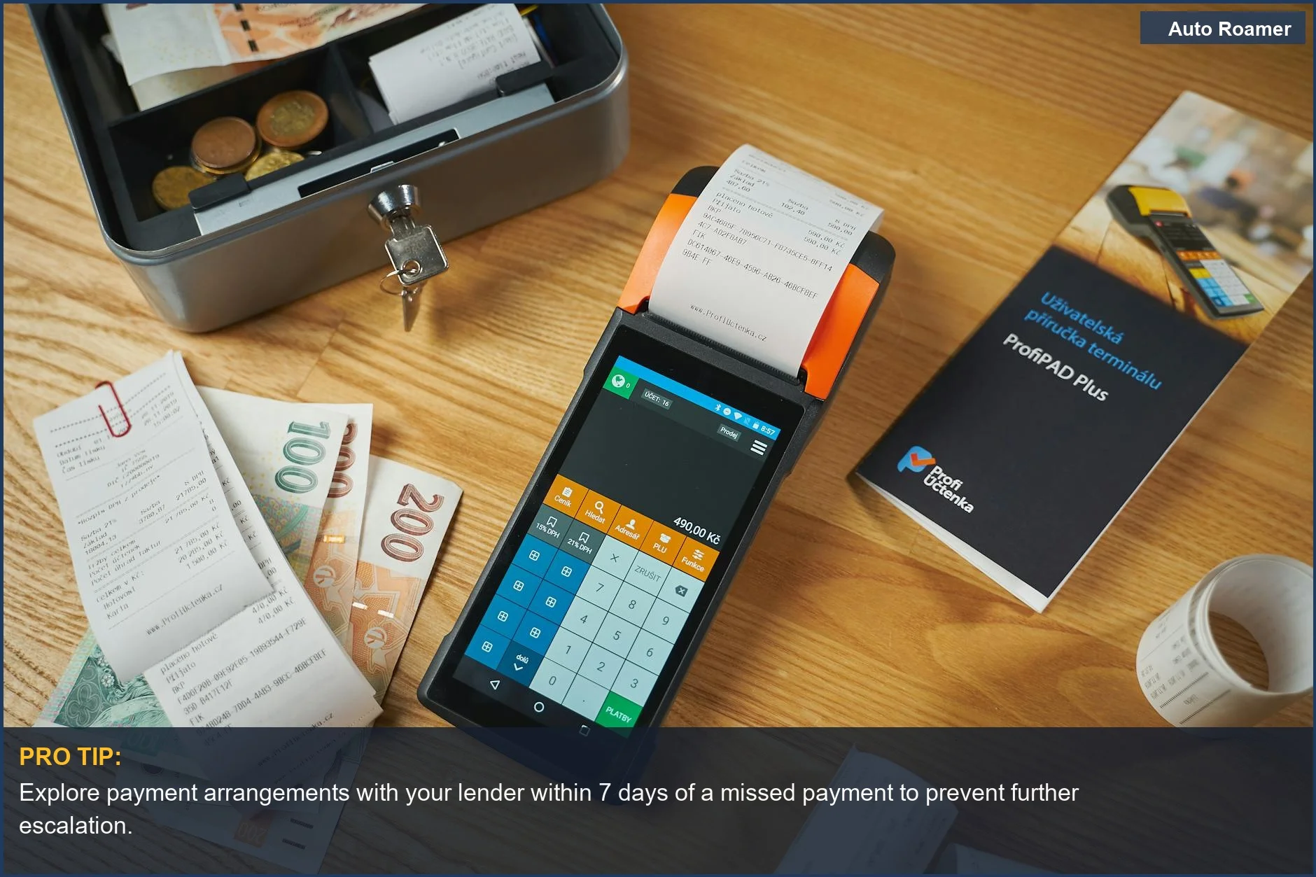 Modern payment terminal with receipts, cash, and manual on a wooden table, symbolizing payment options and car loan consequences.