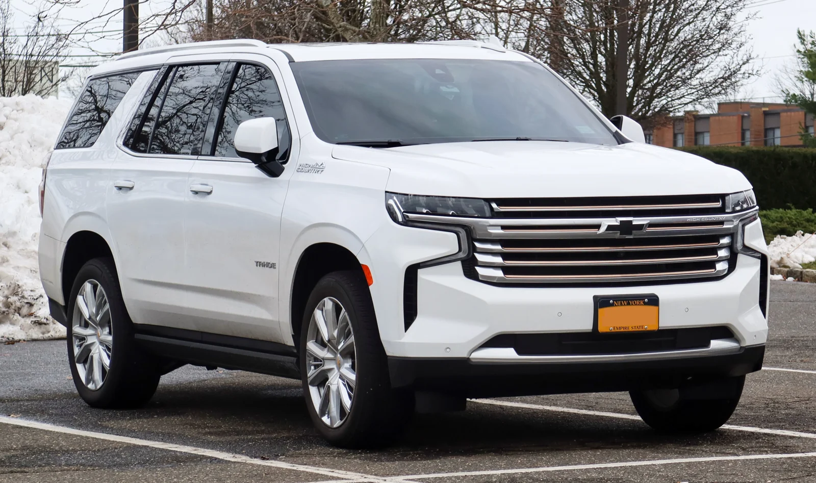 White Chevy Tahoe, front three-quarter view with the split-headlight front.