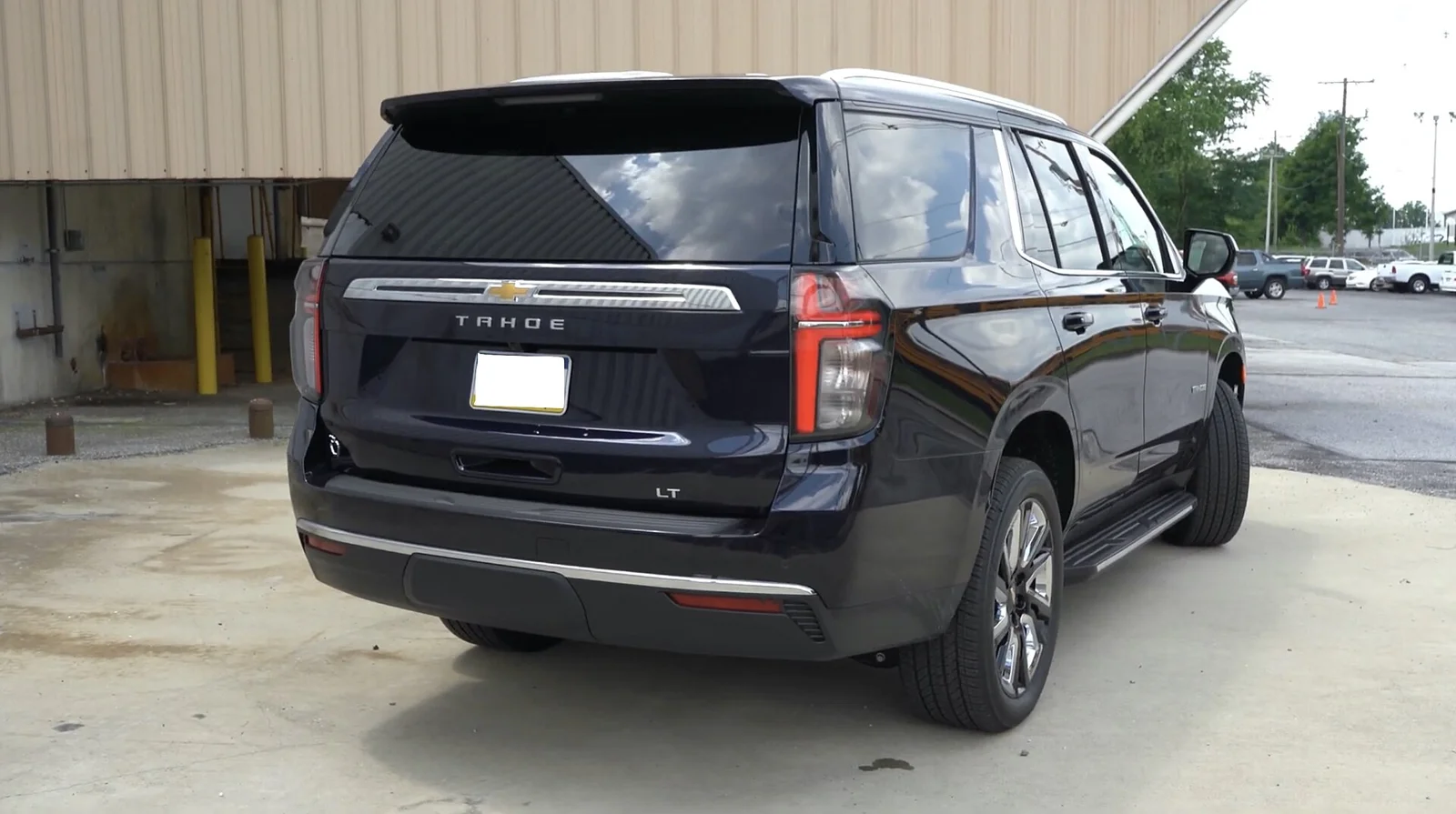 Black Chevy Tahoe, rear three-quarter view showing the tailgate and tall tail lights.