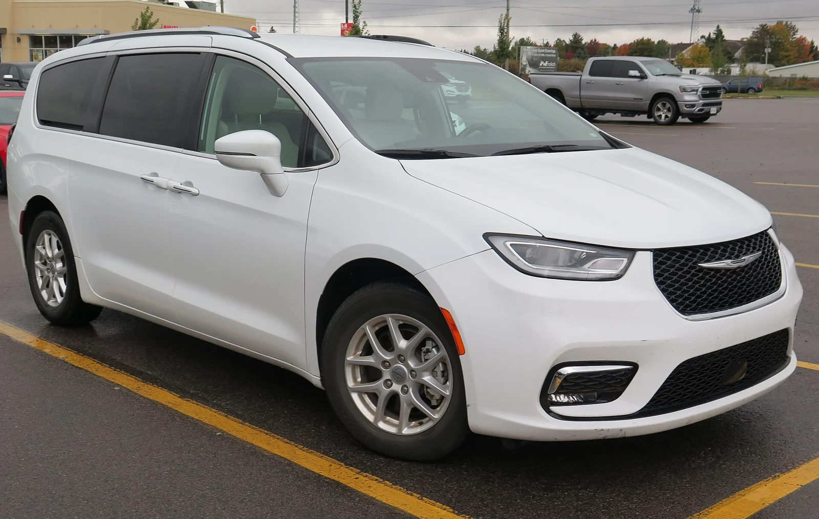 White Chrysler Pacifica, current generation, front three-quarter view with the refreshed grille.