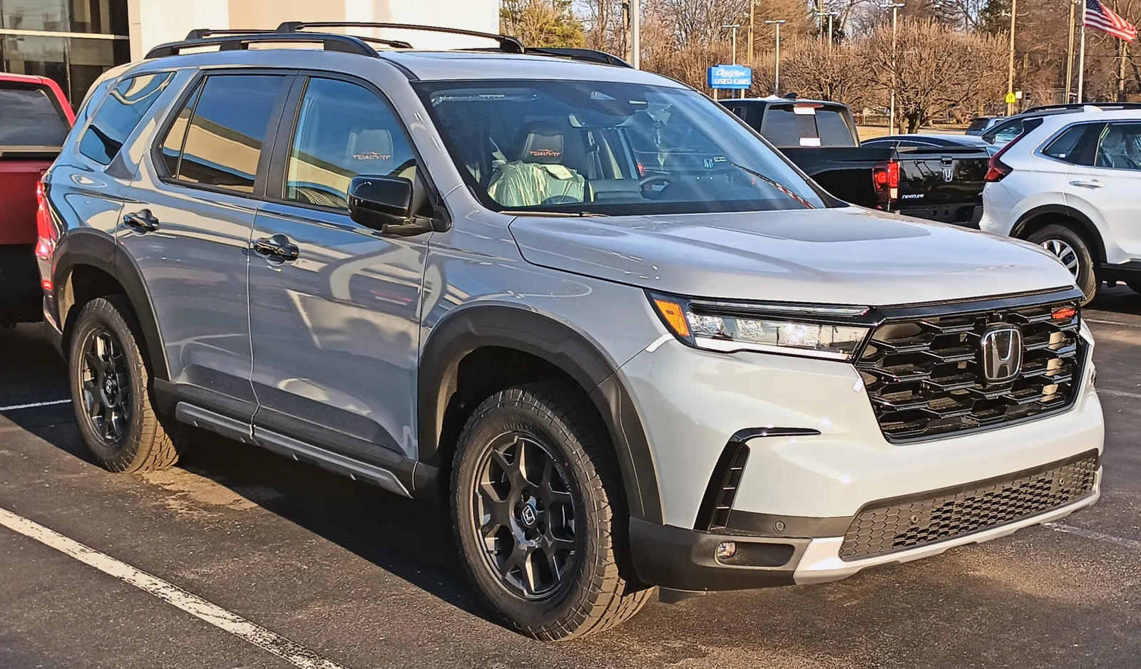 Silver Honda Pilot, current fourth generation, front three-quarter view.