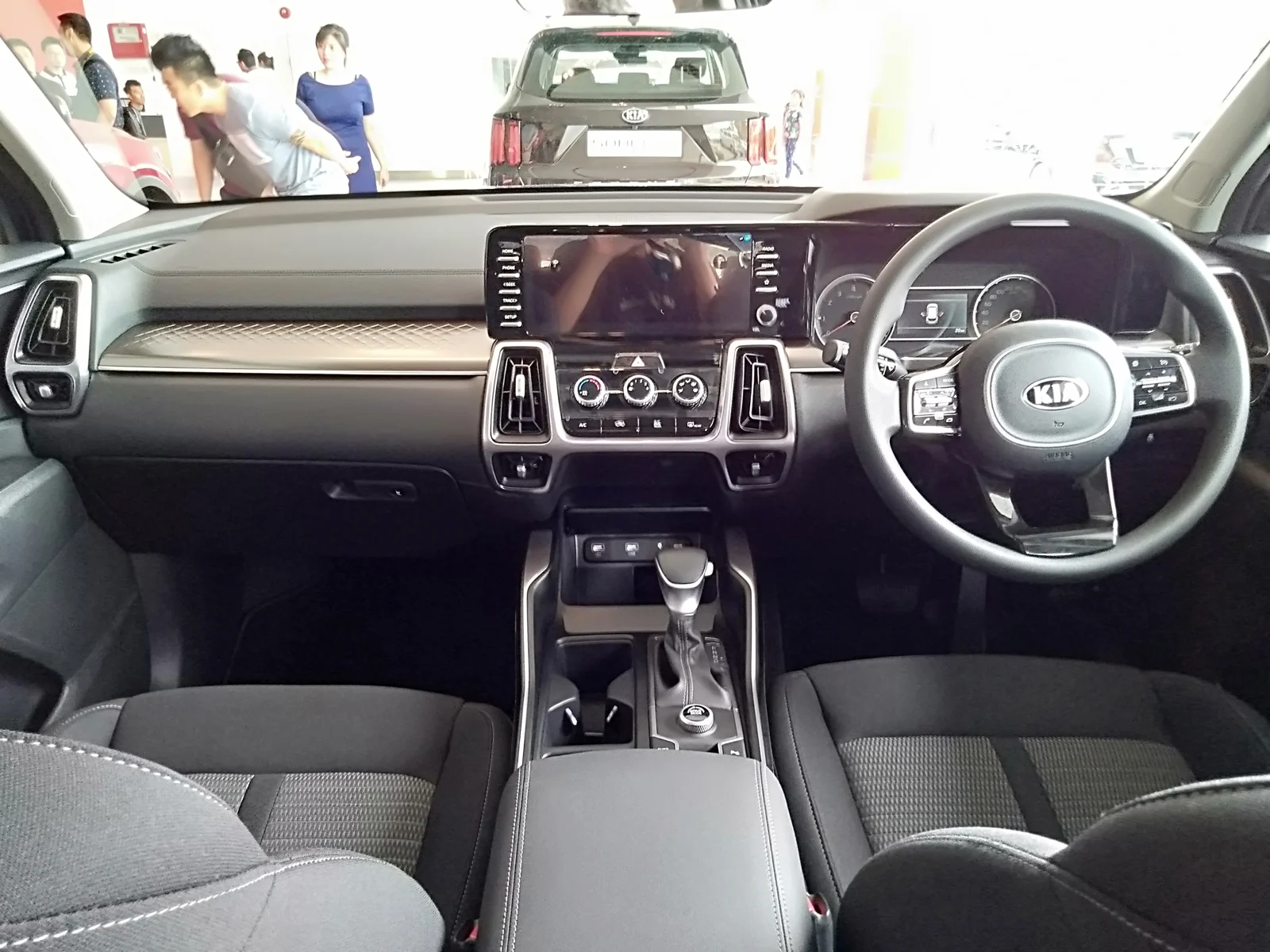 The interior of a current fourth-generation Kia Sorento, showing the dashboard, steering wheel and gear selector.