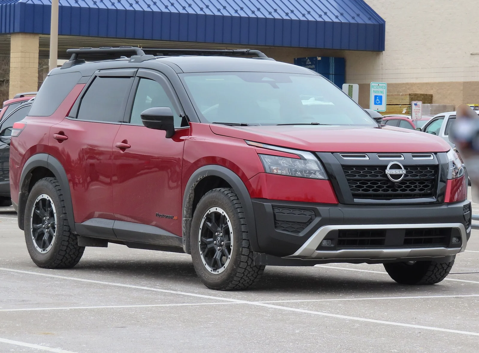 Red Nissan Pathfinder Rock Creek, current R53 generation, front three-quarter view with black exterior trim.