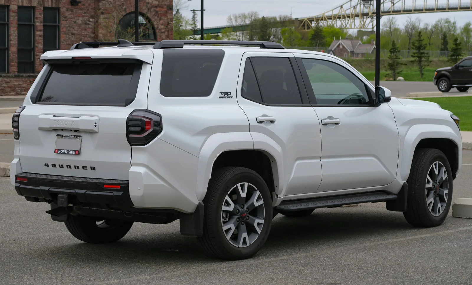 White Toyota 4Runner, current sixth generation, rear three-quarter view showing the tailgate and 4RUNNER lettering.