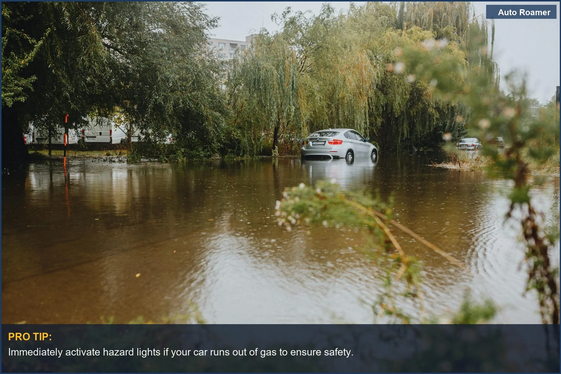 Car struggling through a flooded street after heavy rainfall.