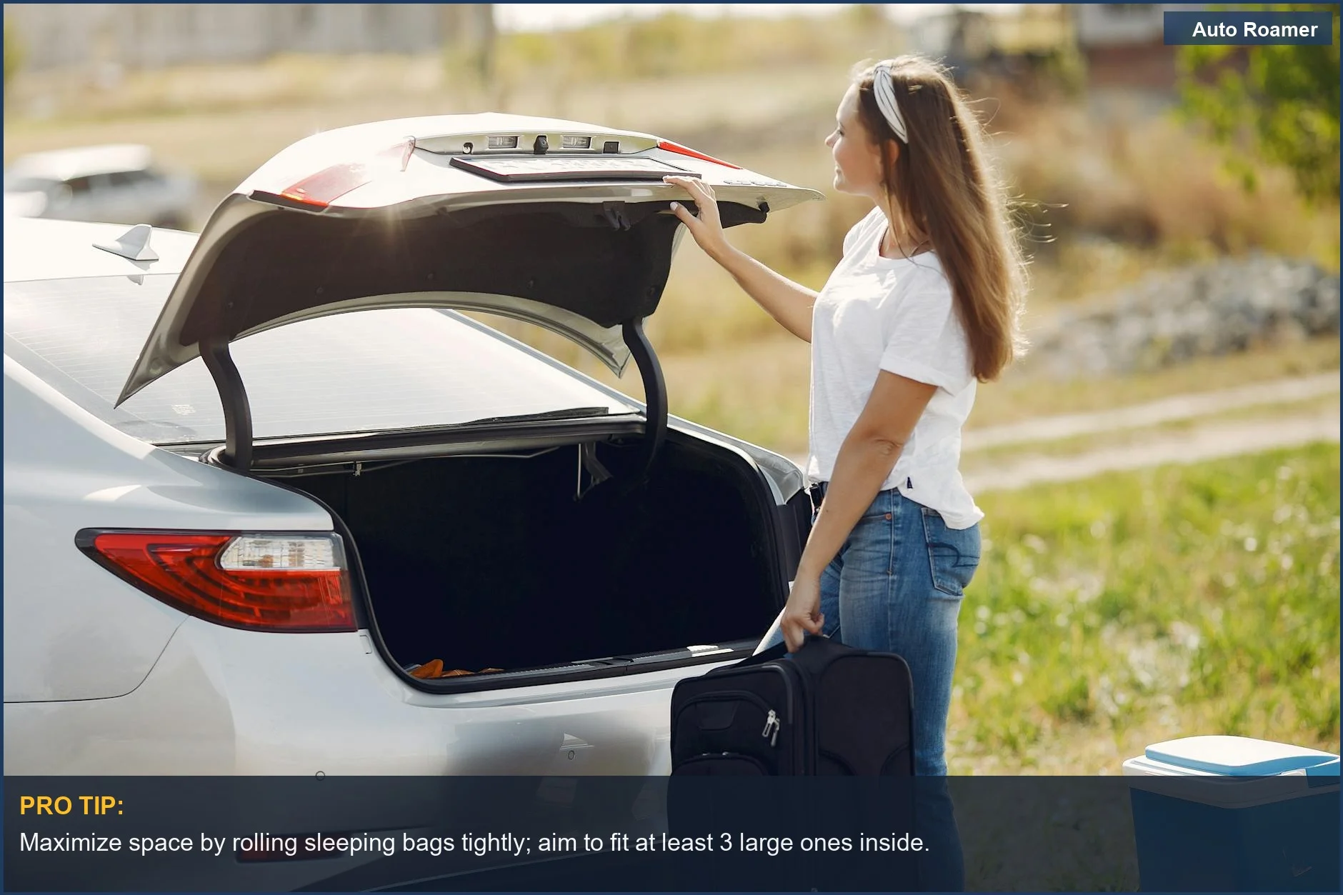 Woman packing camping gear into an open roof rack cargo box for a weekend road trip.