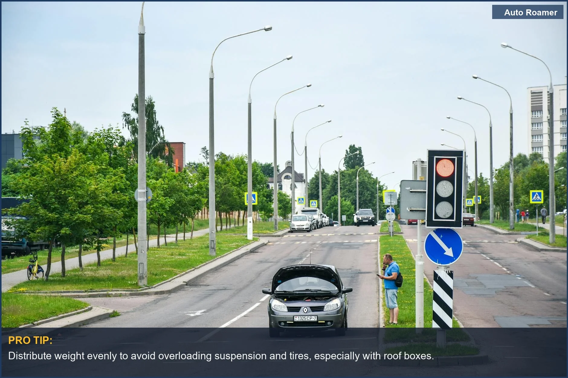 Frustrated man checks phone by car on city street, road trip gear causes breakdown.