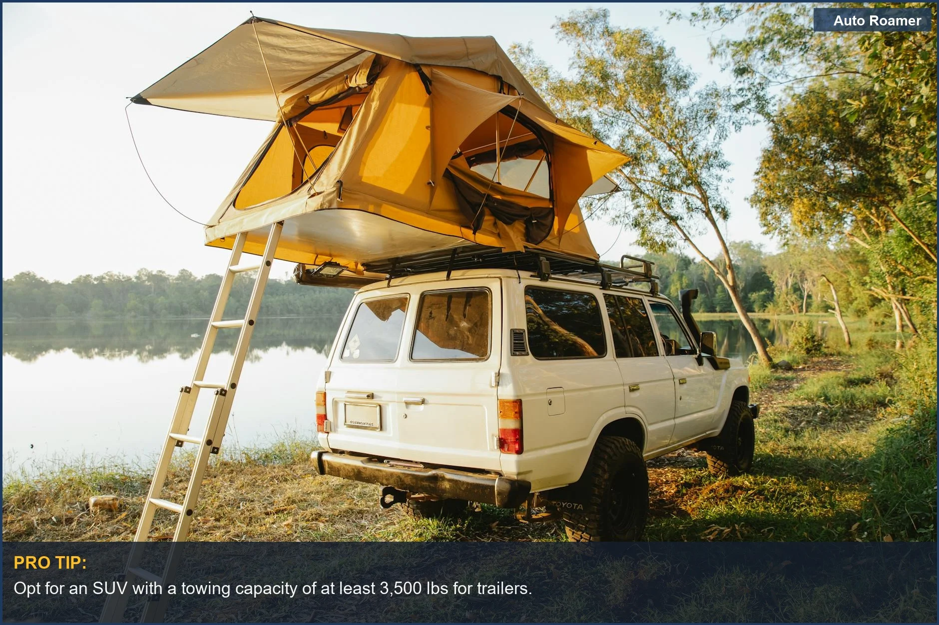 Off-road car with rooftop tent beside picturesque lake, perfect for camping trips.