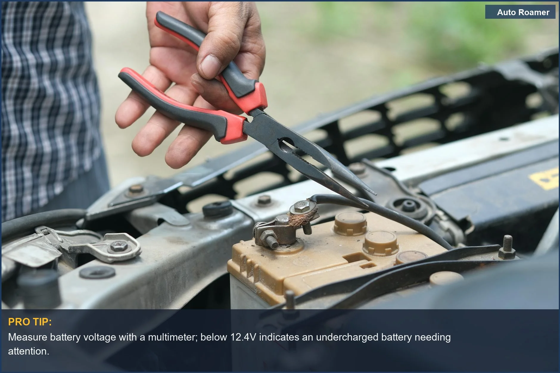 Person checking car battery terminals with pliers, a step in diagnosing battery issues in winter.