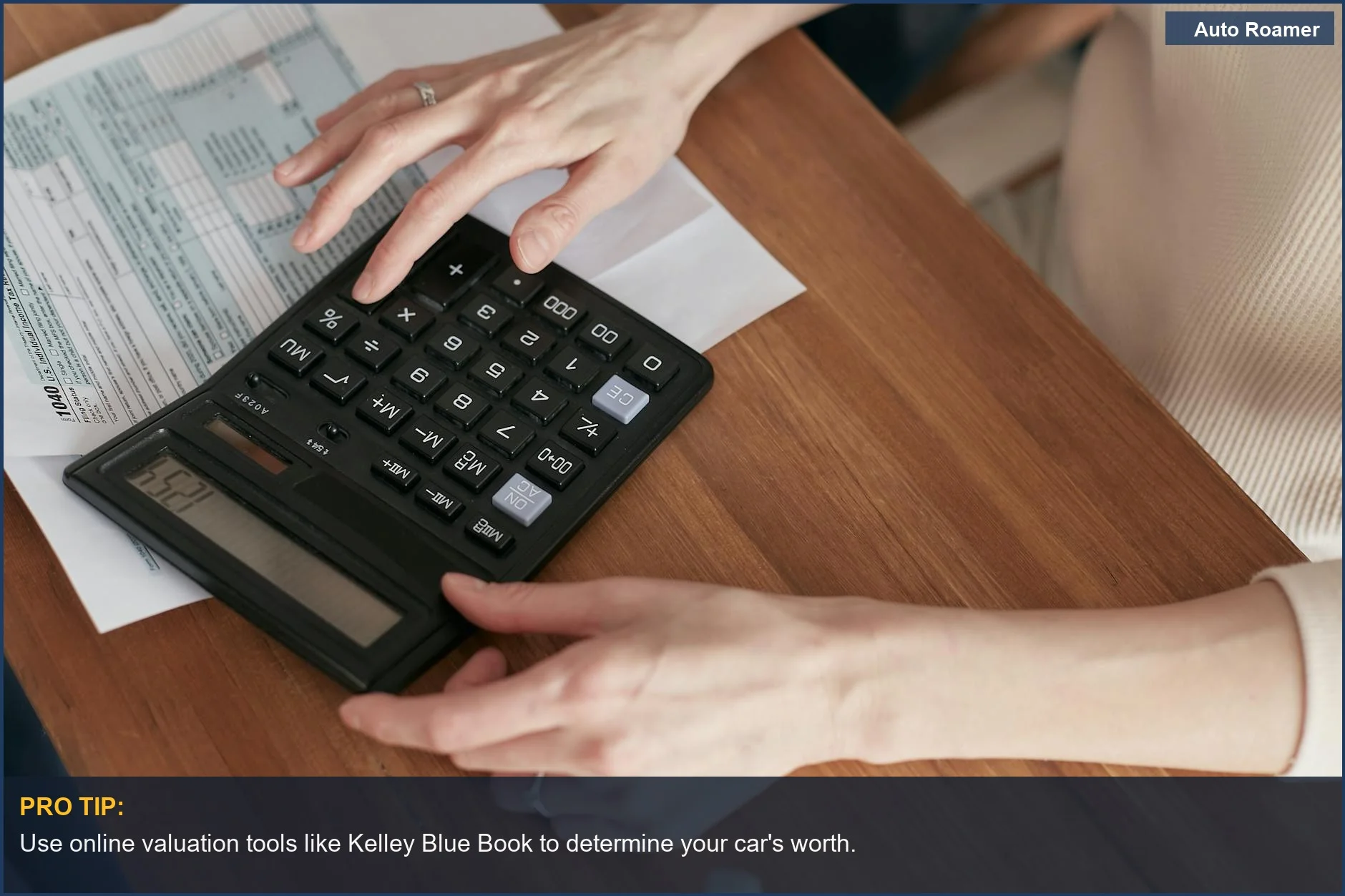 Woman using a calculator at home emphasizes researching your car's true market value.