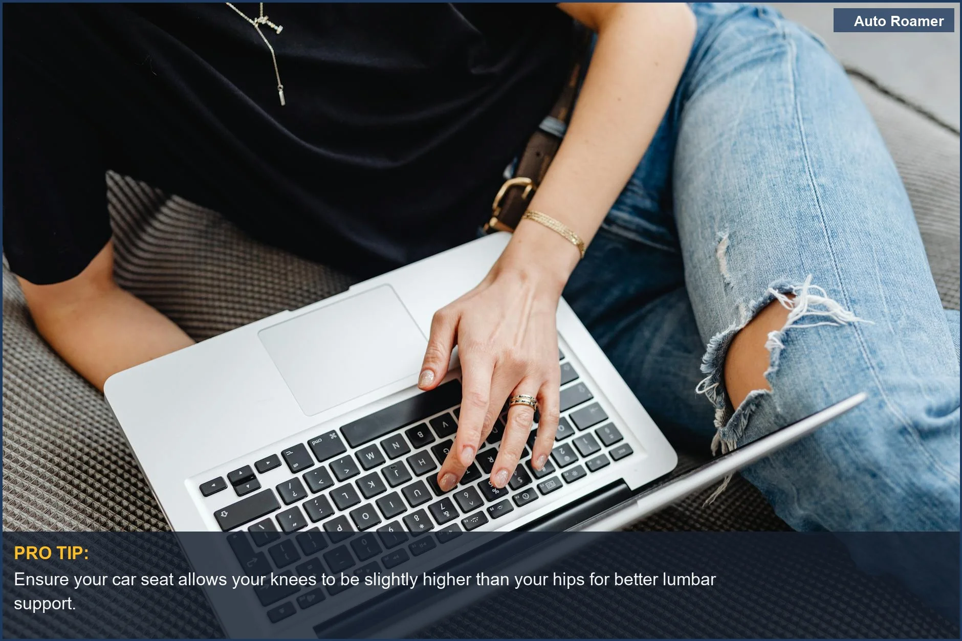 Young adult typing on a laptop on a sofa, demonstrating comfortable but potentially unsupportive seating relevant to driving posture.