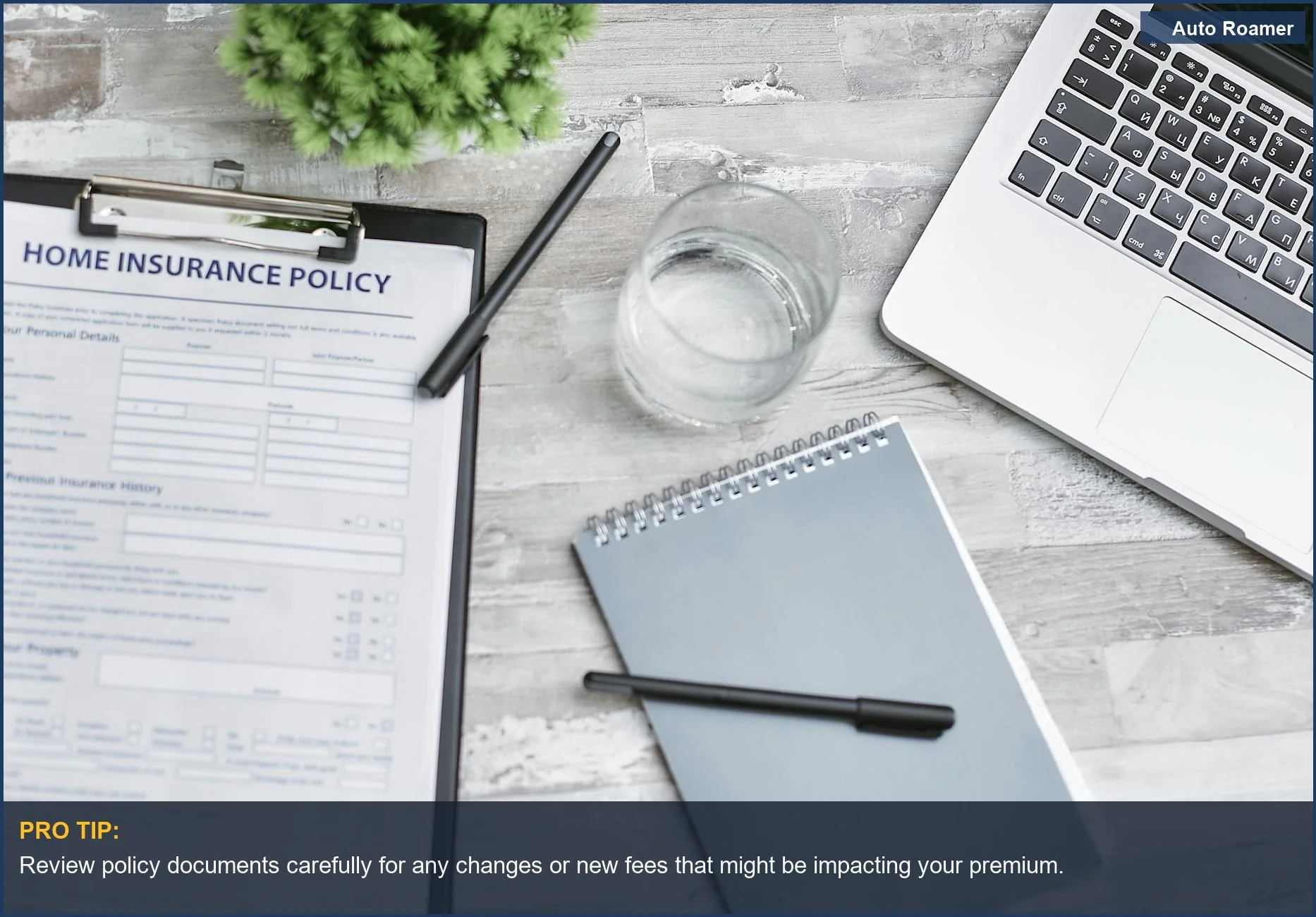 Escritorio con póliza de seguro de hogar, portátil y cuaderno, ilustrando por qué las primas del seguro de coche aumentan inesperadamente.