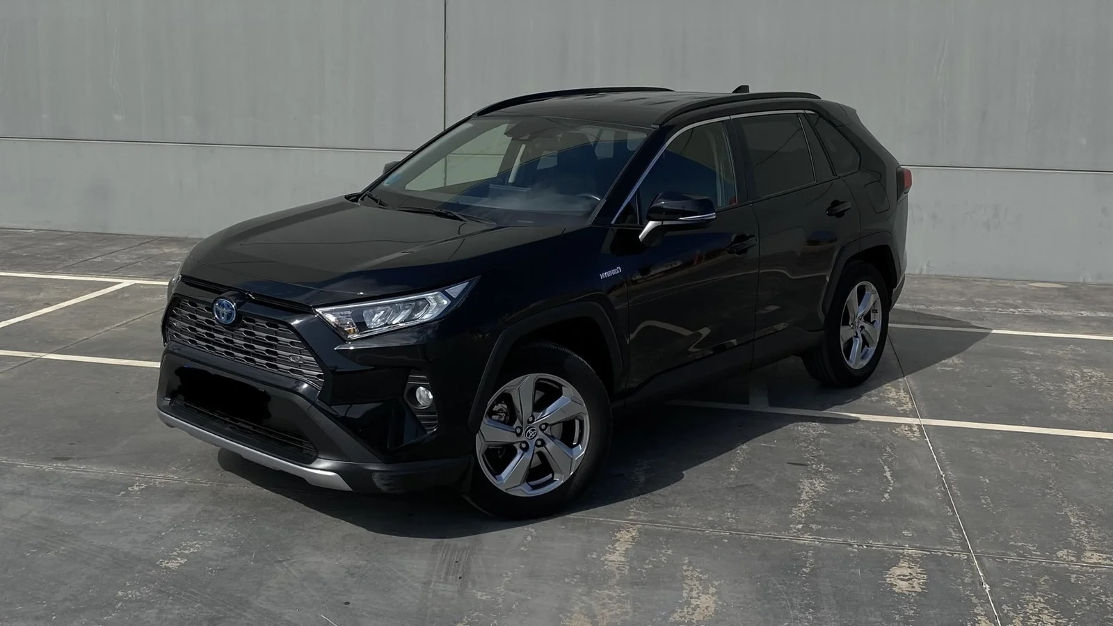 Black Toyota RAV4, current fifth-generation XA50, front three-quarter view parked on a street.