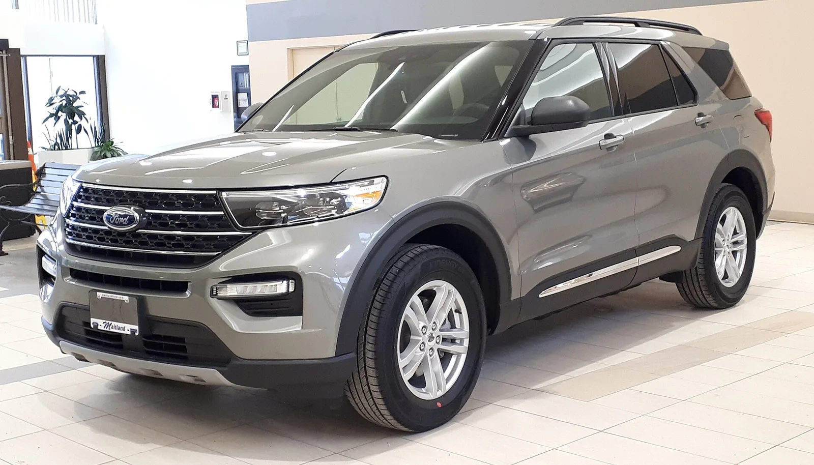 A grey Ford Explorer, current sixth generation, front three-quarter view with a chrome grille.