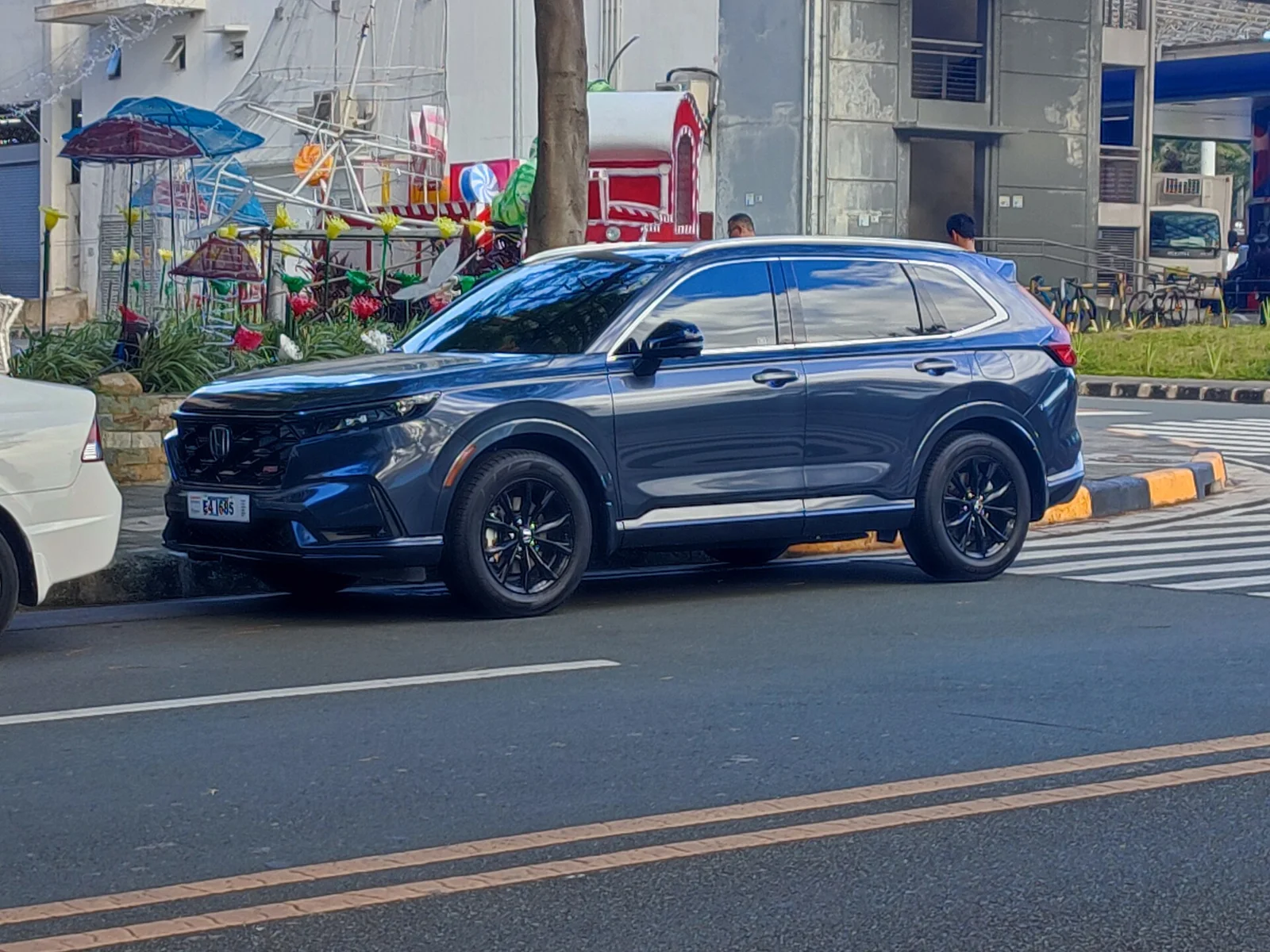 Blue Honda CR-V, current sixth generation, front three-quarter view on a city street.