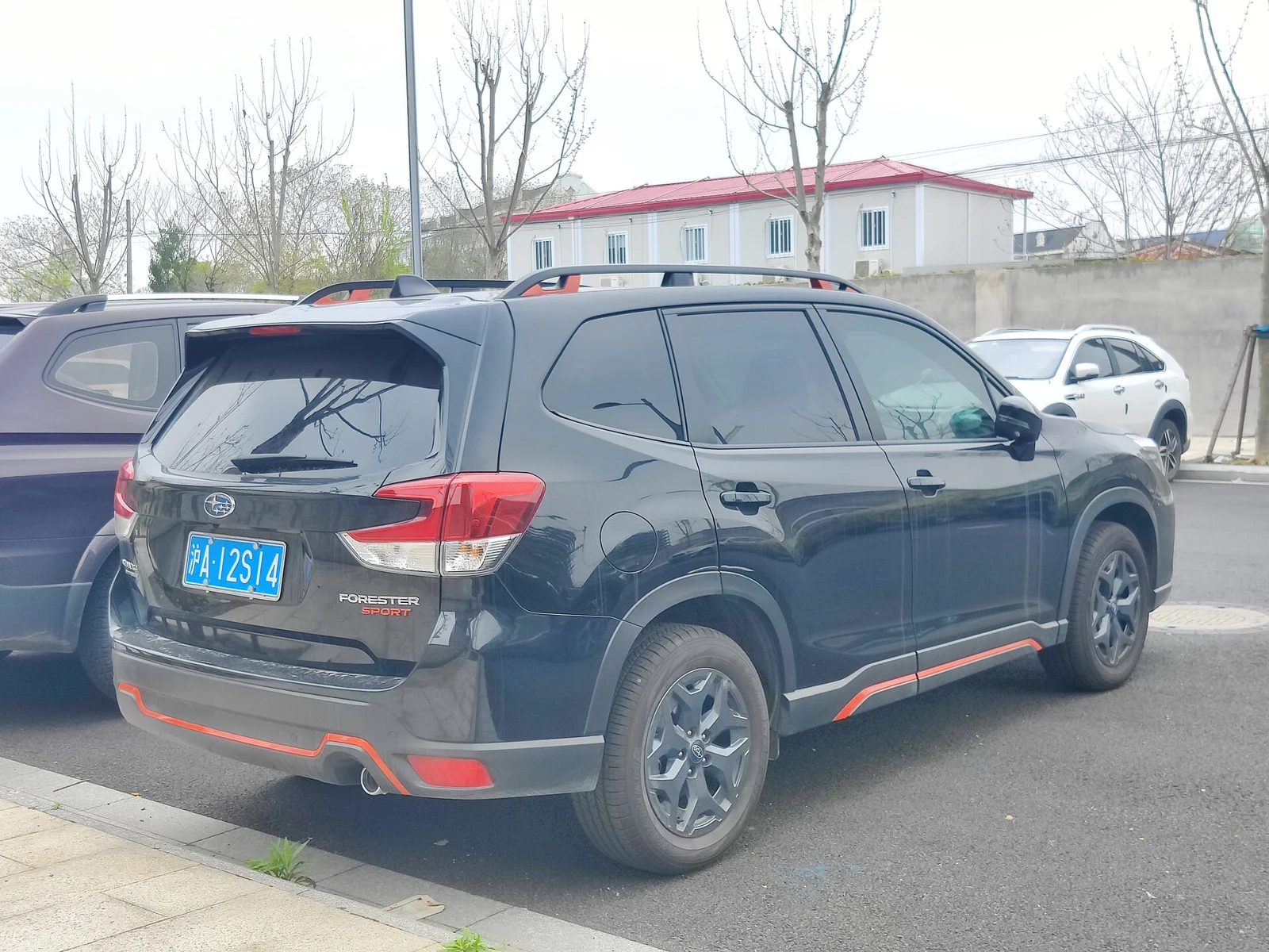 Black Subaru Forester Sport, fifth-generation SK, rear three-quarter view with red accent trim.