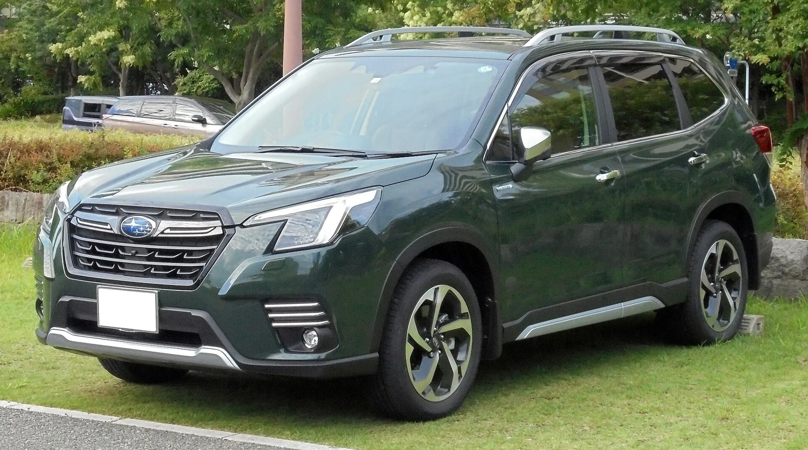 Green Subaru Forester, fifth-generation SK, front three-quarter view showing the hexagonal grille.