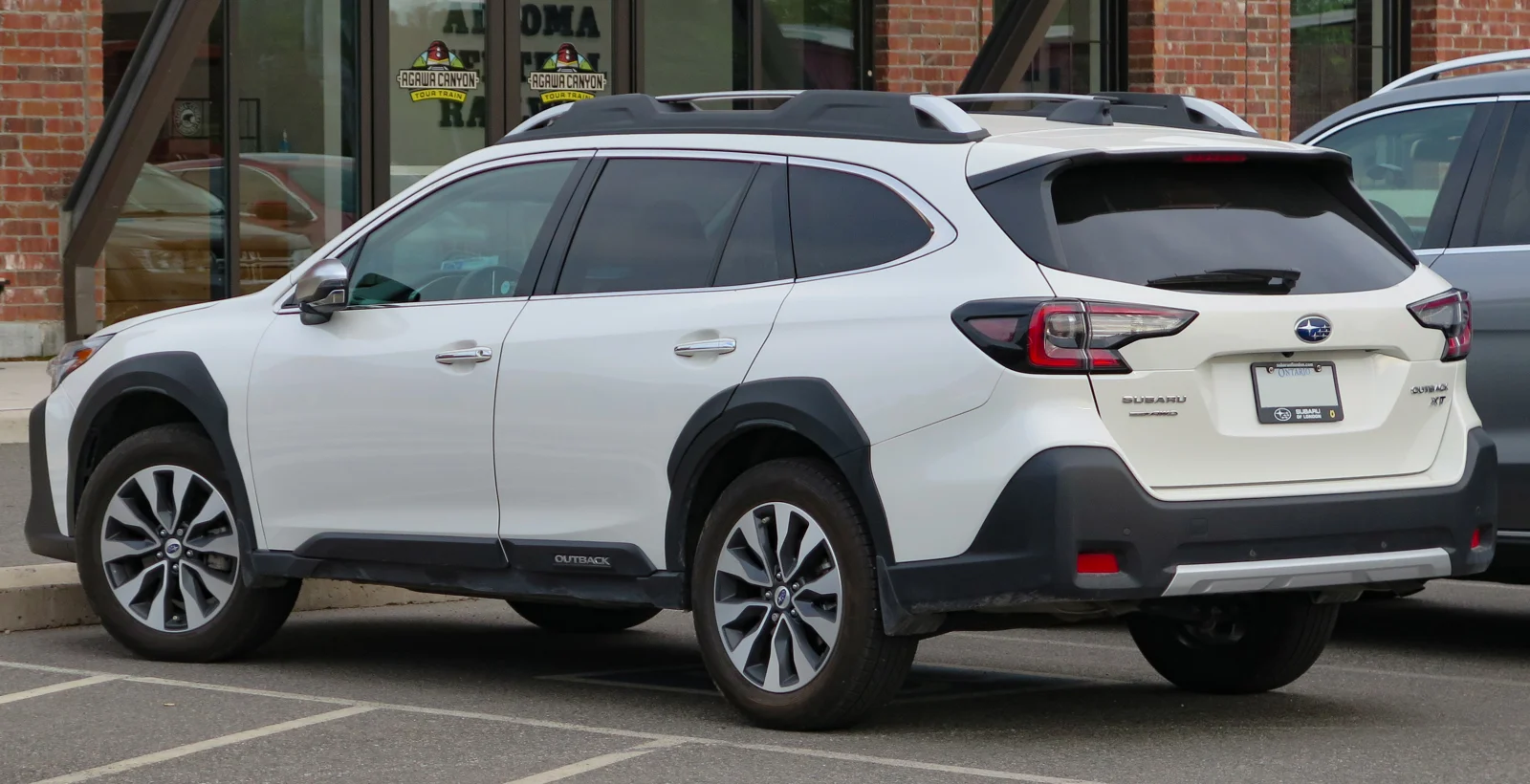 White Subaru Outback, current sixth-generation, rear three-quarter view showing the tailgate and roof rails.