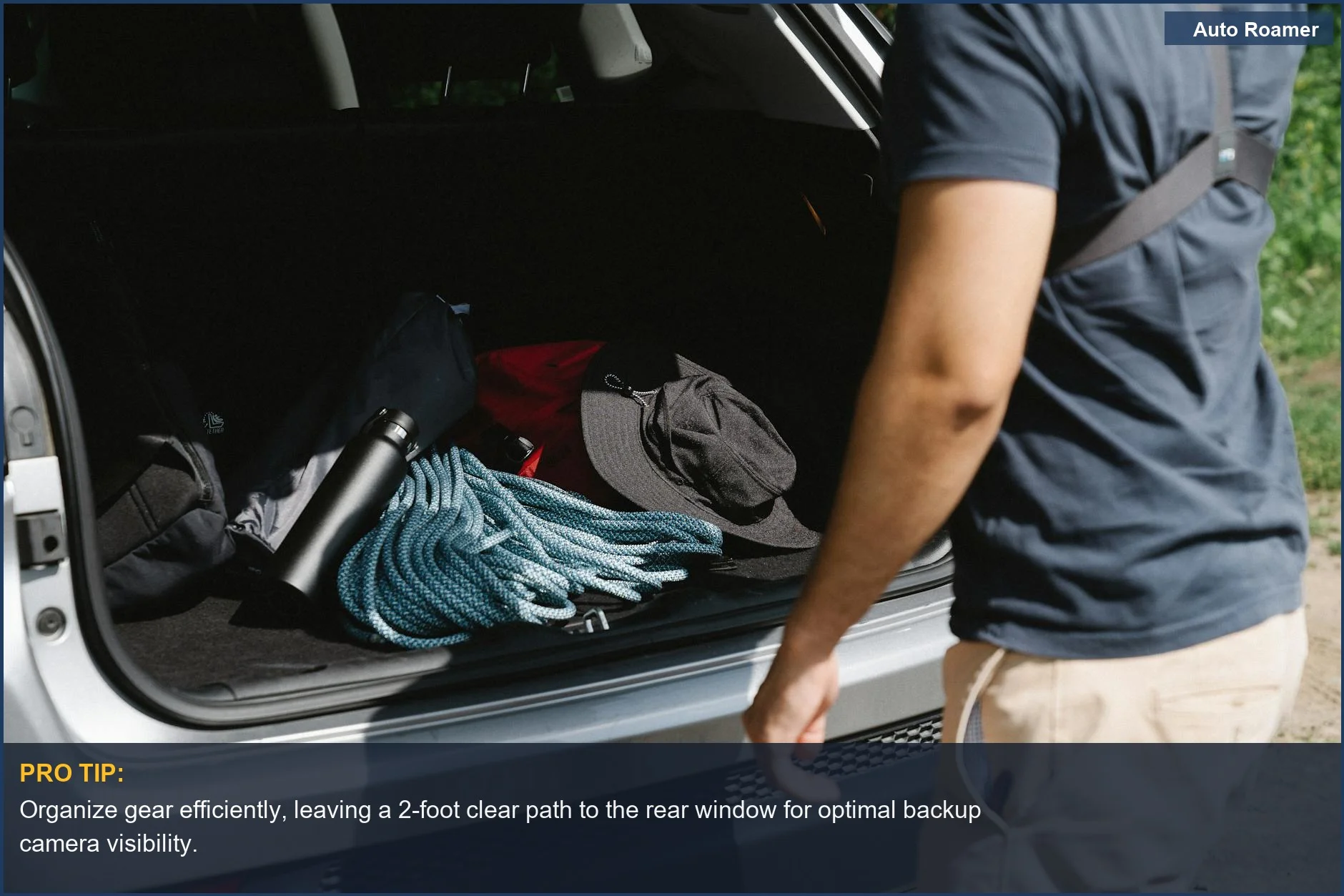 Man efficiently organizing camping gear in a car trunk, emphasizing the need for visibility.