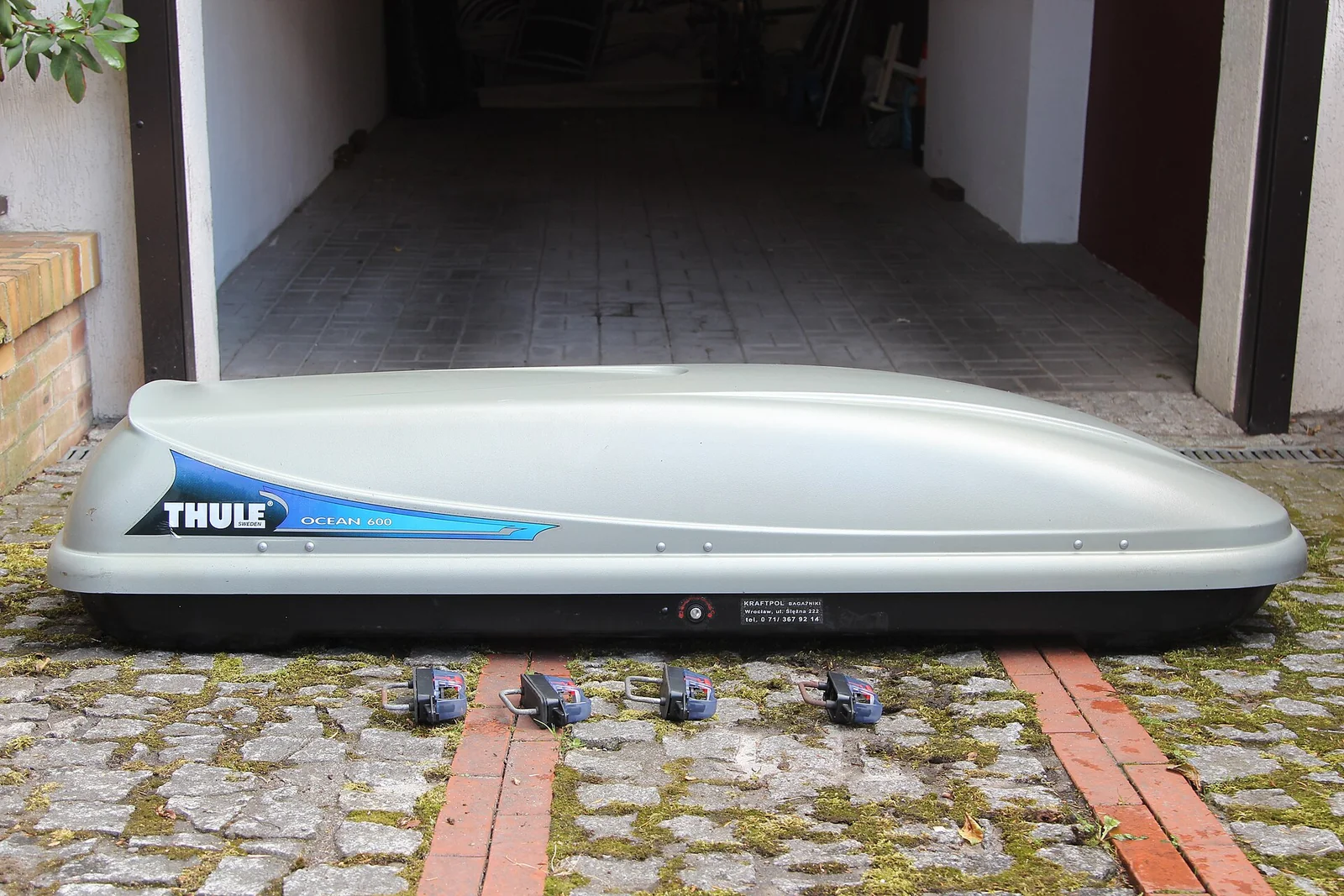 A Thule rooftop cargo box sitting on the ground, one of the two premium hard-shell boxes this guide compares.